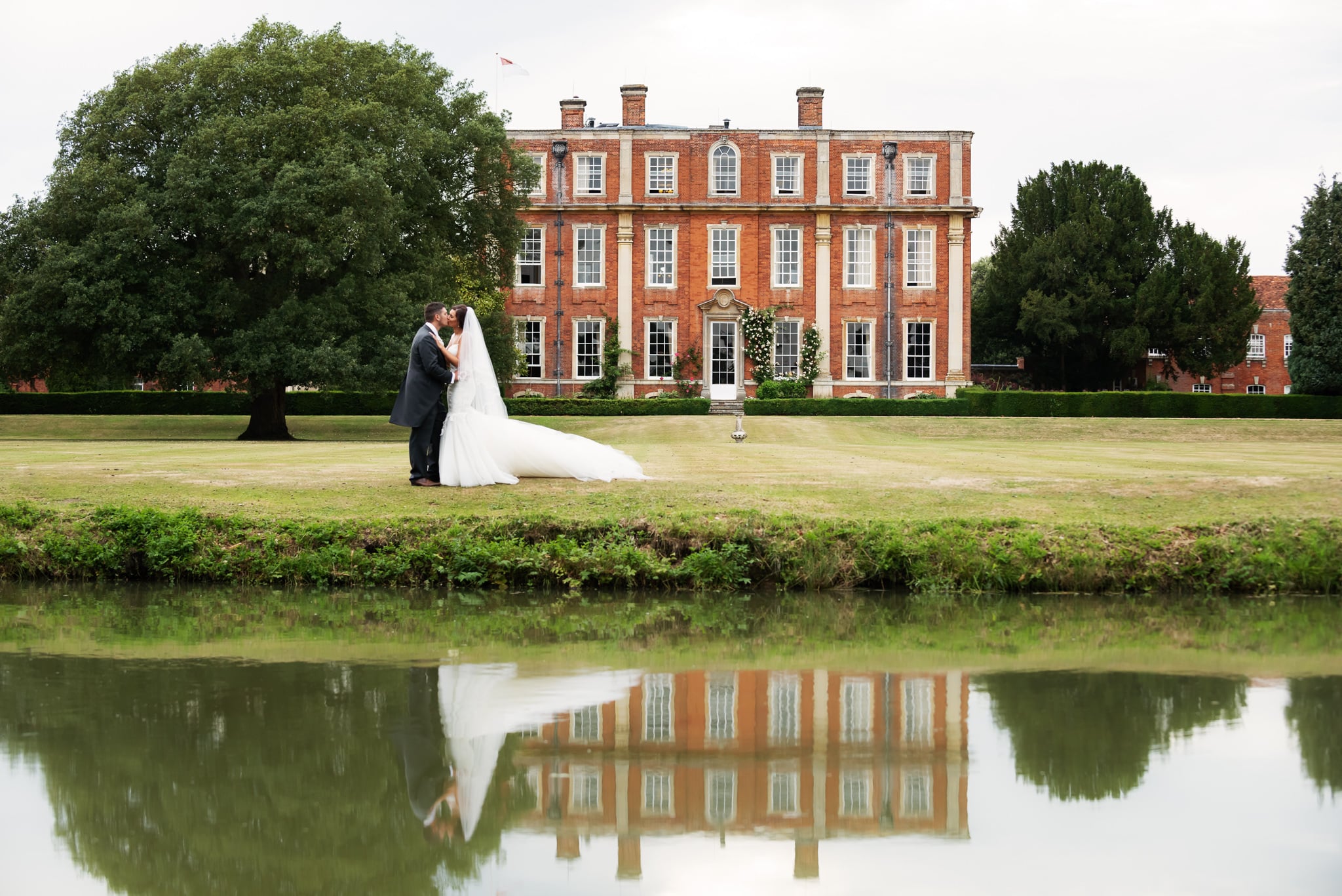 Portrait of bride and groom with Chicheley Hall behind them