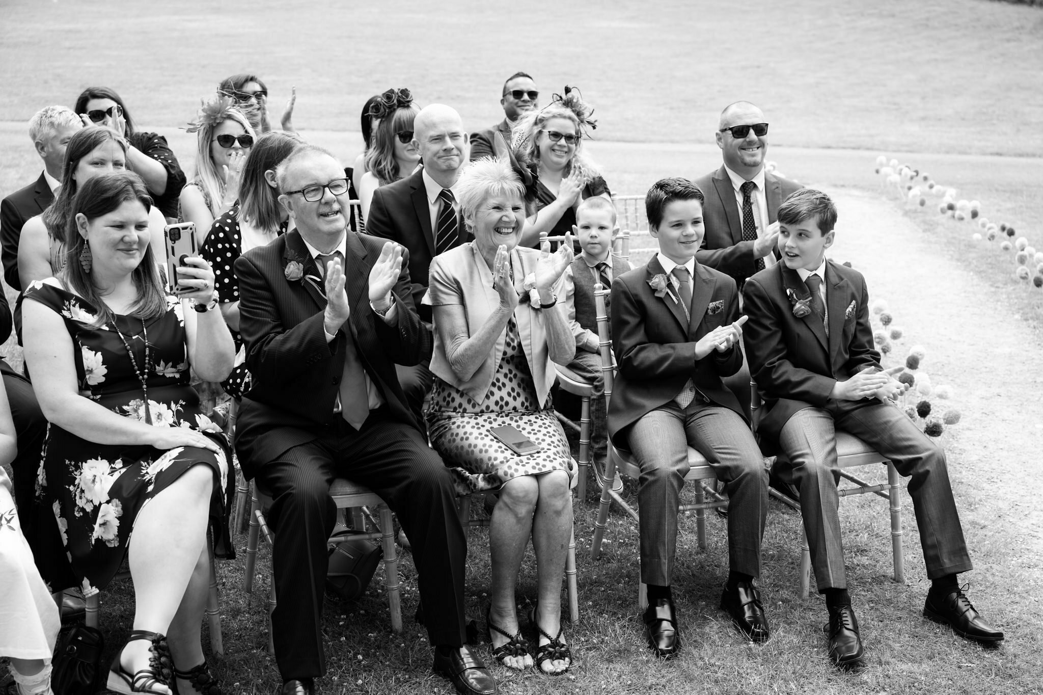 Wedding guests clapping at the end of the wedding ceremony.