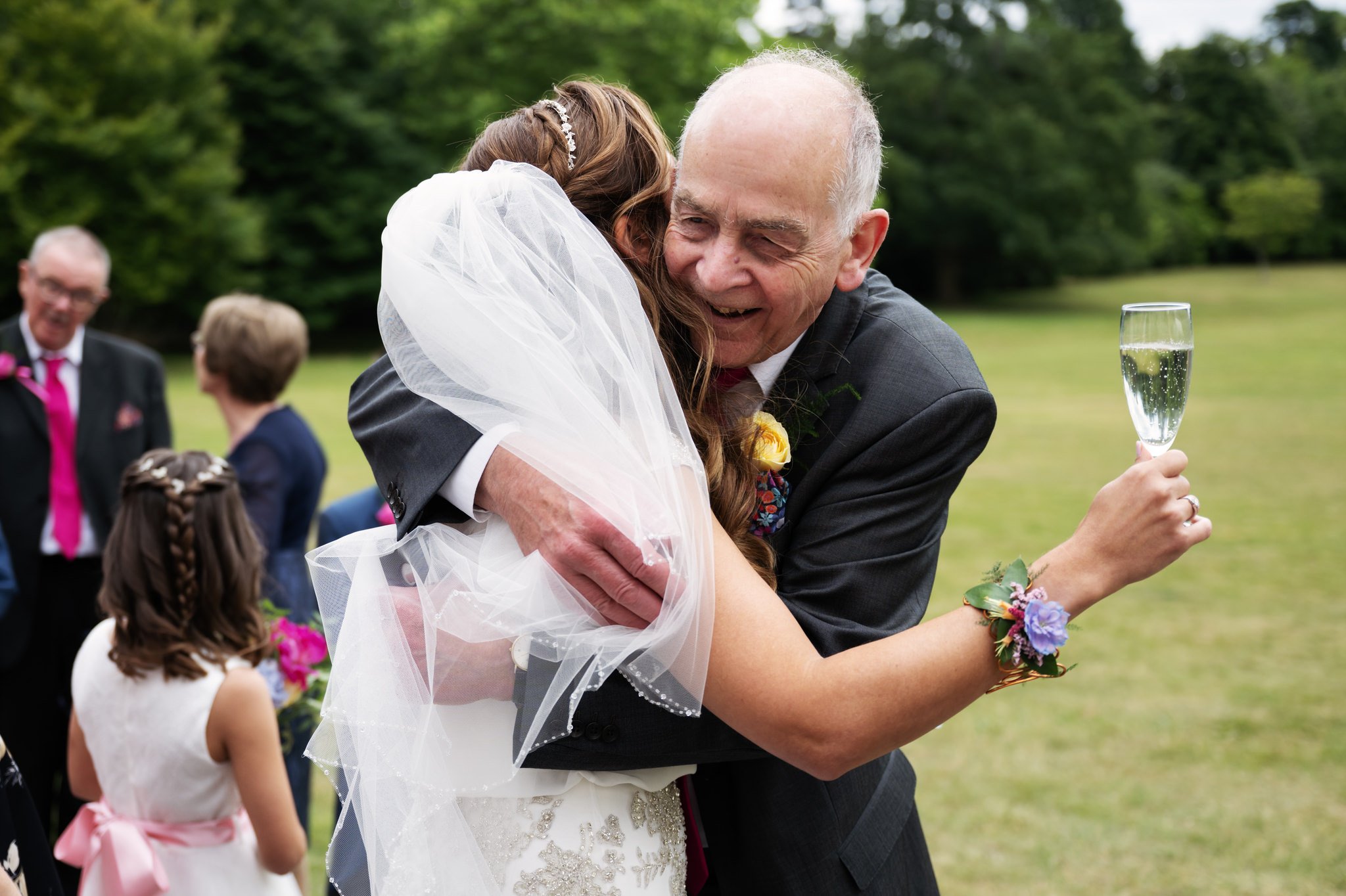 Attended wedding photo of the bride hugging her dad.