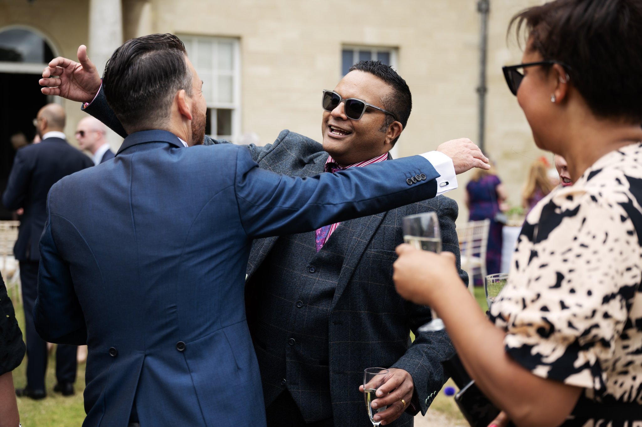 The groom is congratulated by one of his wedding guests at the end of the wedding ceremony.
