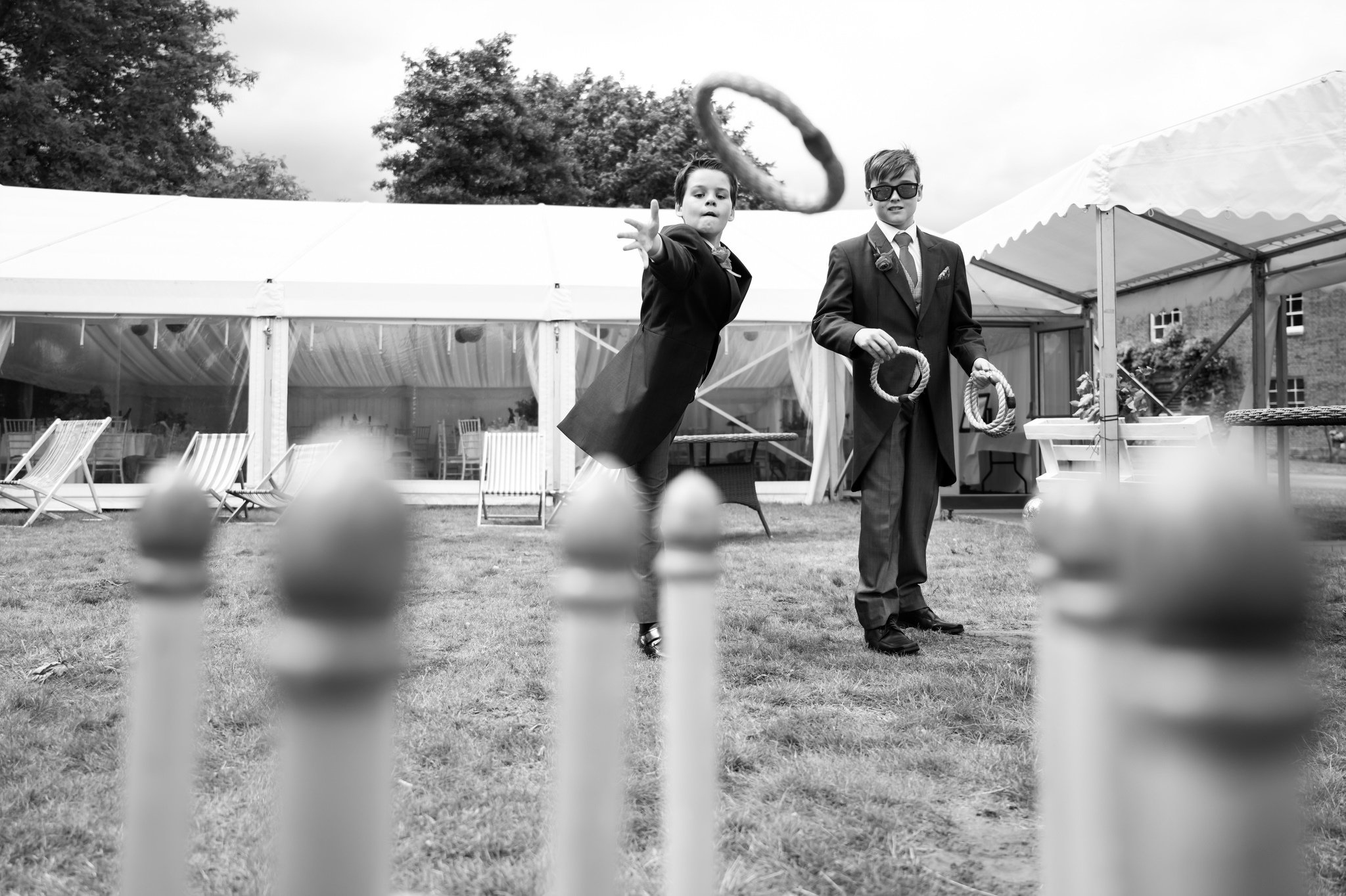 Two page boys play a ring toss game during a Hitchin Priory wedding reception.