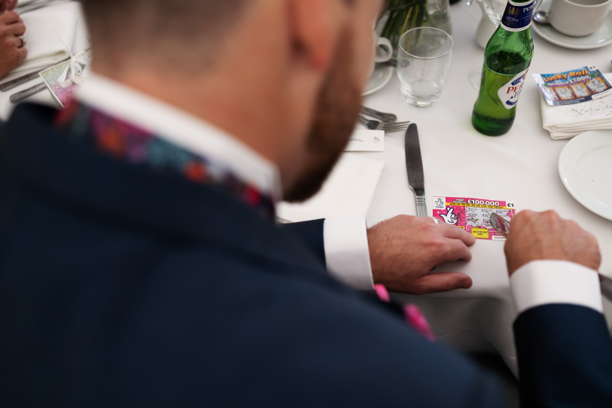 Wedding guests scratching a scratch card which was used as a wedding favour.
