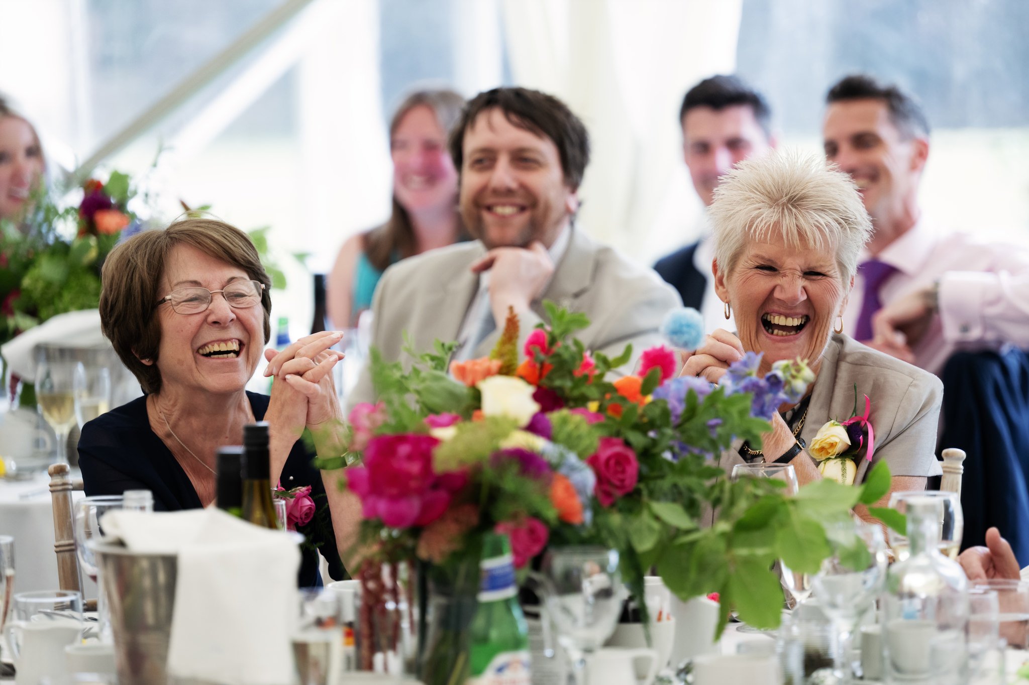 Mother of the bride and mother of the groom laughing during the wedding speeches.