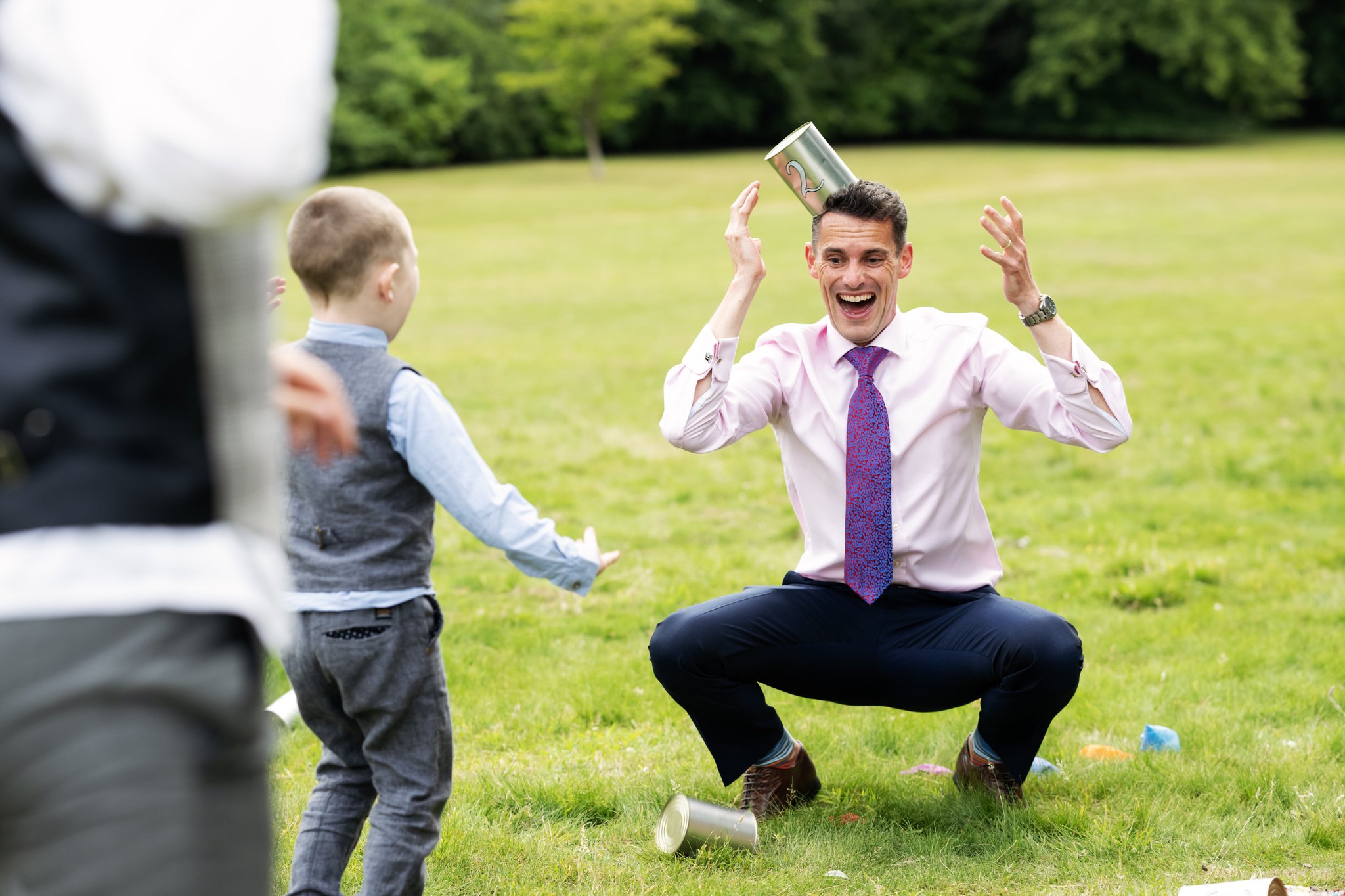 A candid photo of a wedding guest playing with kids.