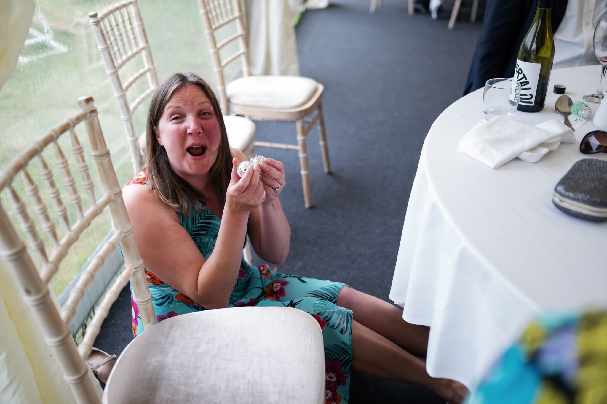 A wedding guest falls off her chair laughing.