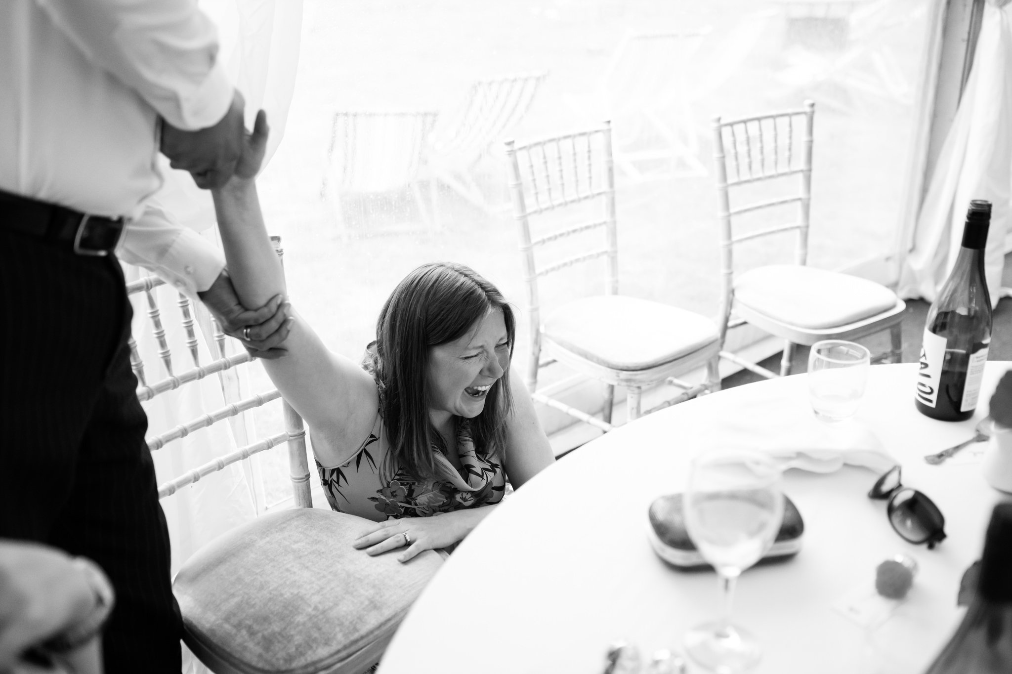 Wedding guest is being picked up off the falling off her chair laughing.