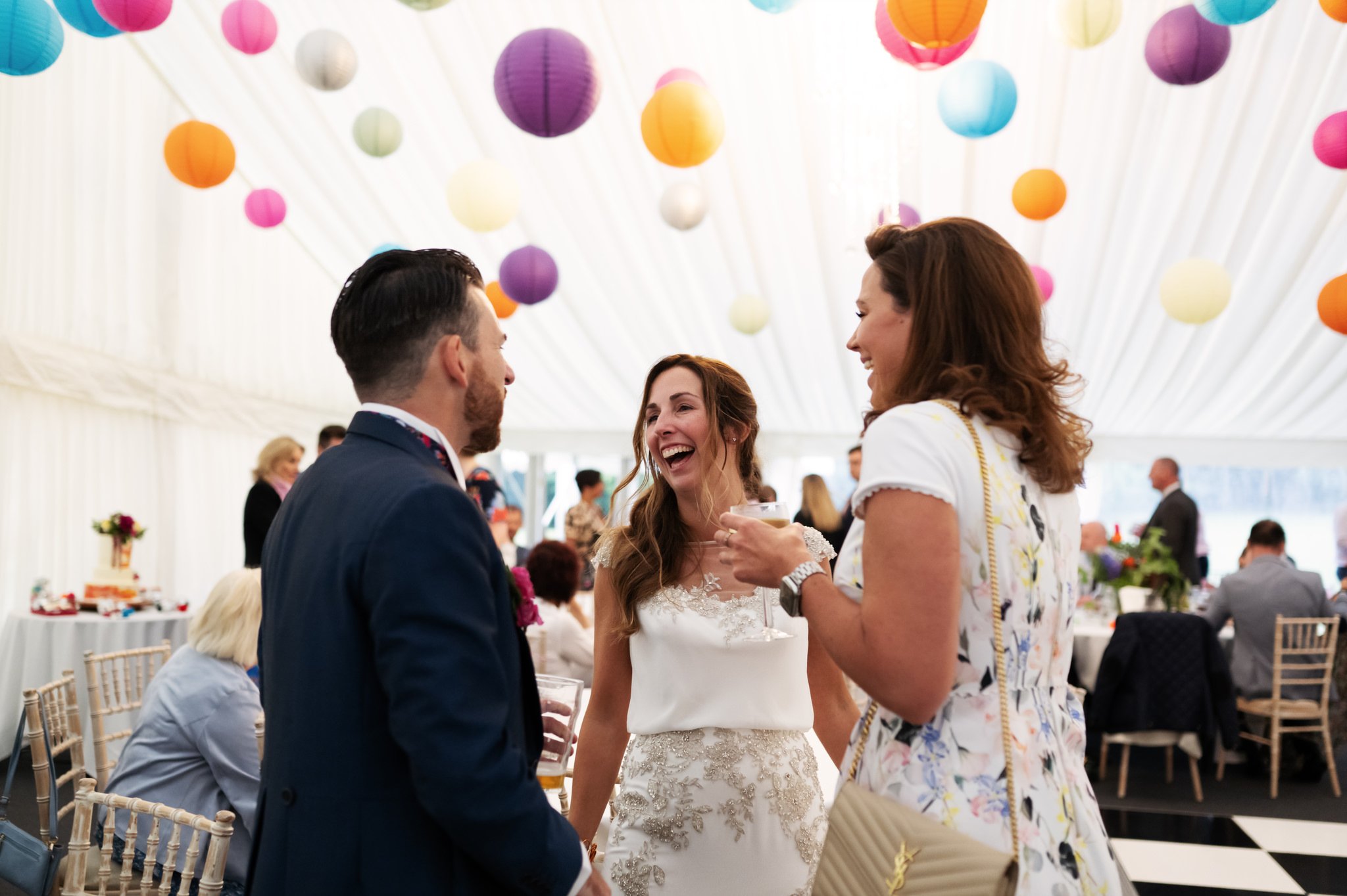 The bride and groom talking with a wedding guest at a Hitchin Priory wedding reception.