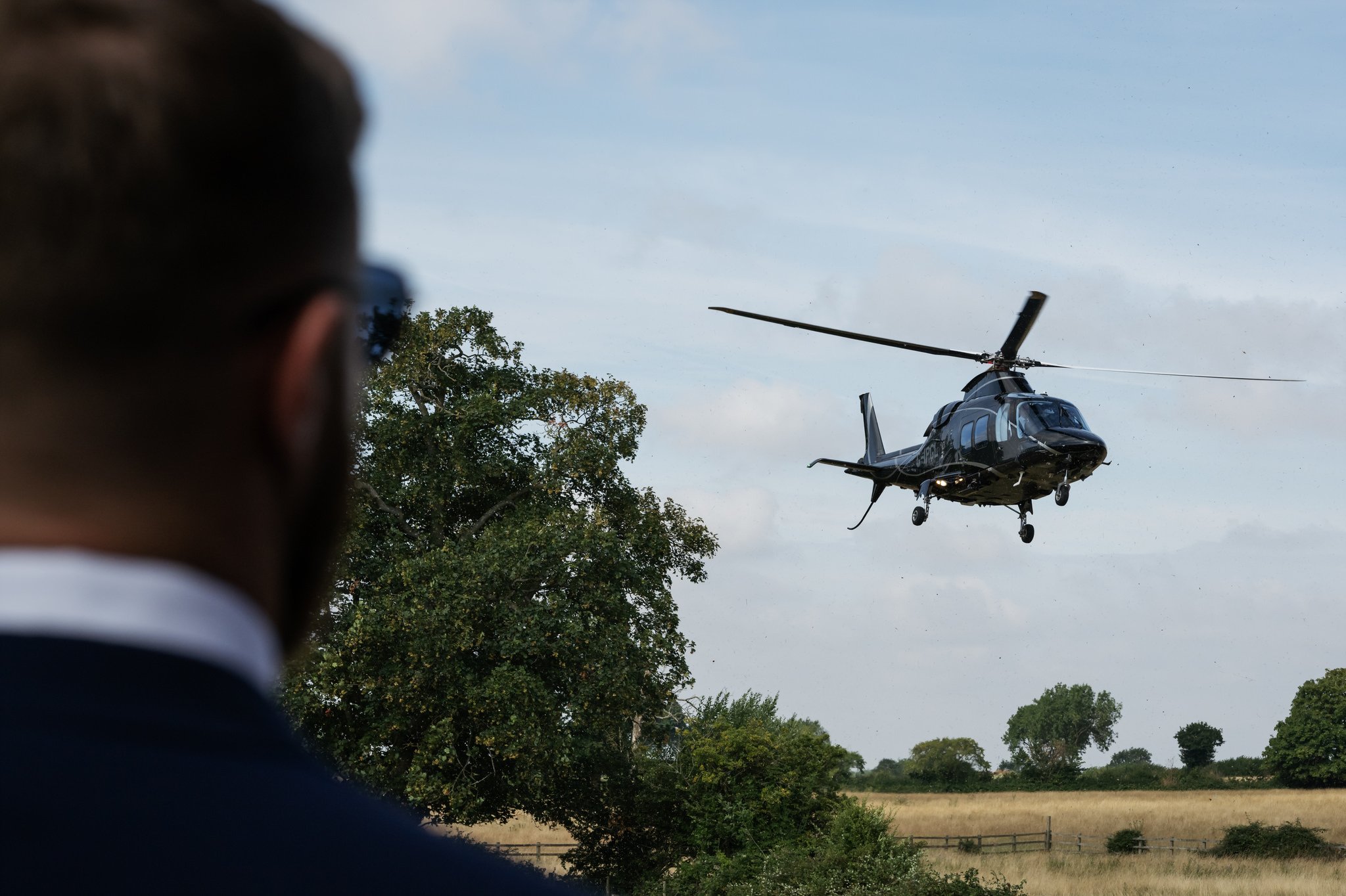 The groom watches as a helicopter arrives at Horwood House ready to take him to Stowe House for his wedding.