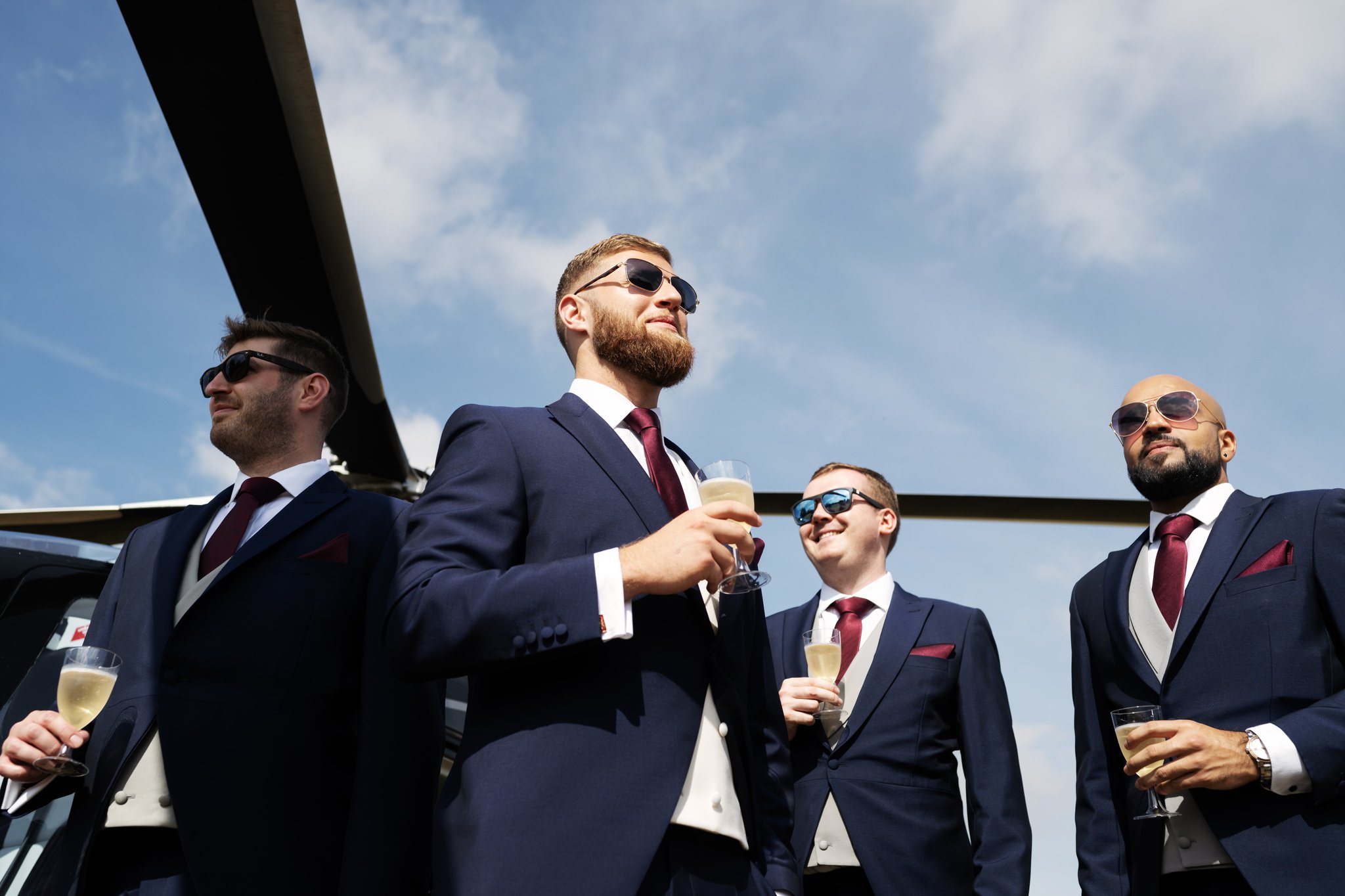 The groom and his groomsmen posing in front of a helicopter at Horwood House.