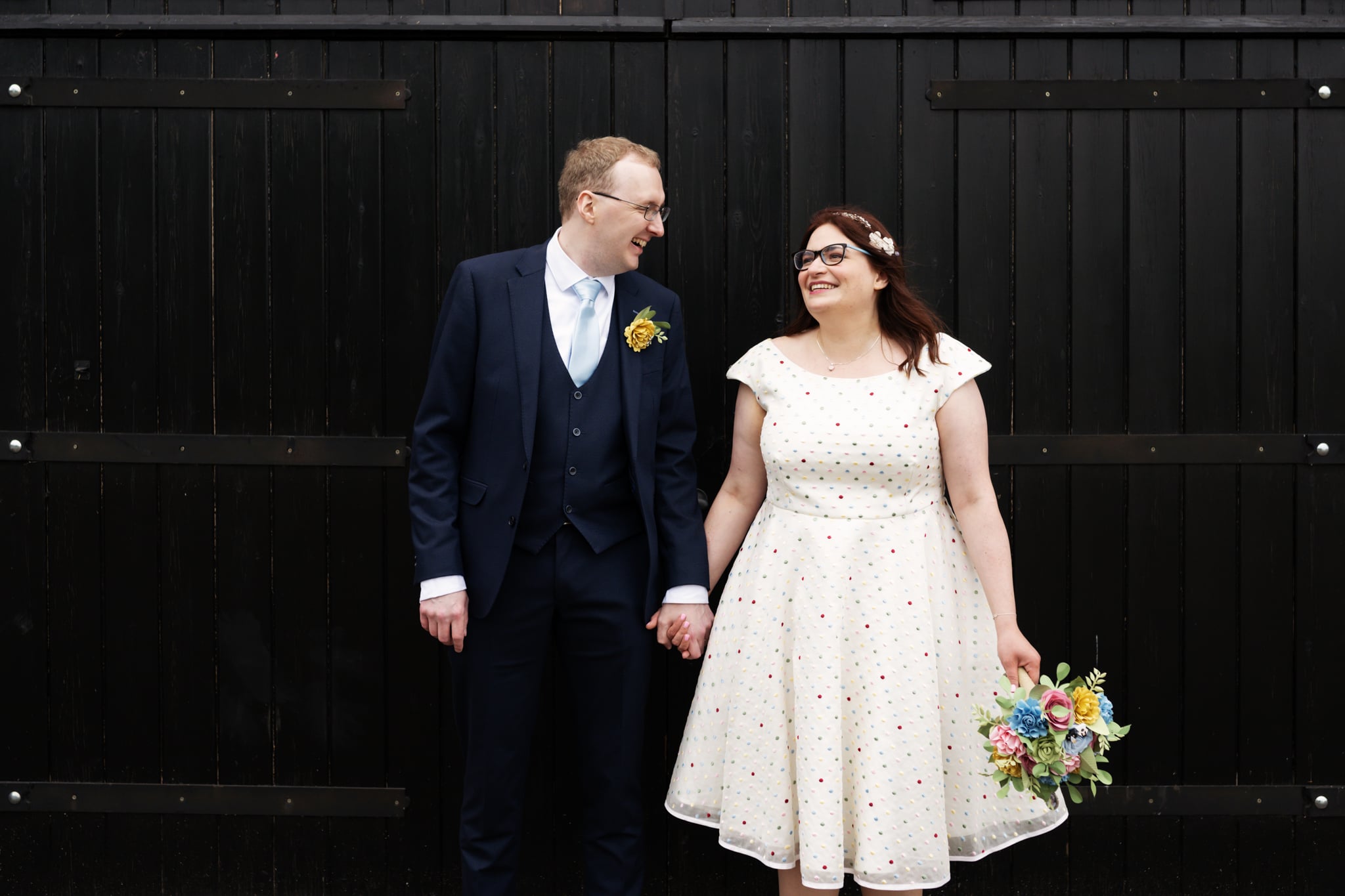 Couple portrait in front of the barn doors at Milling Barn