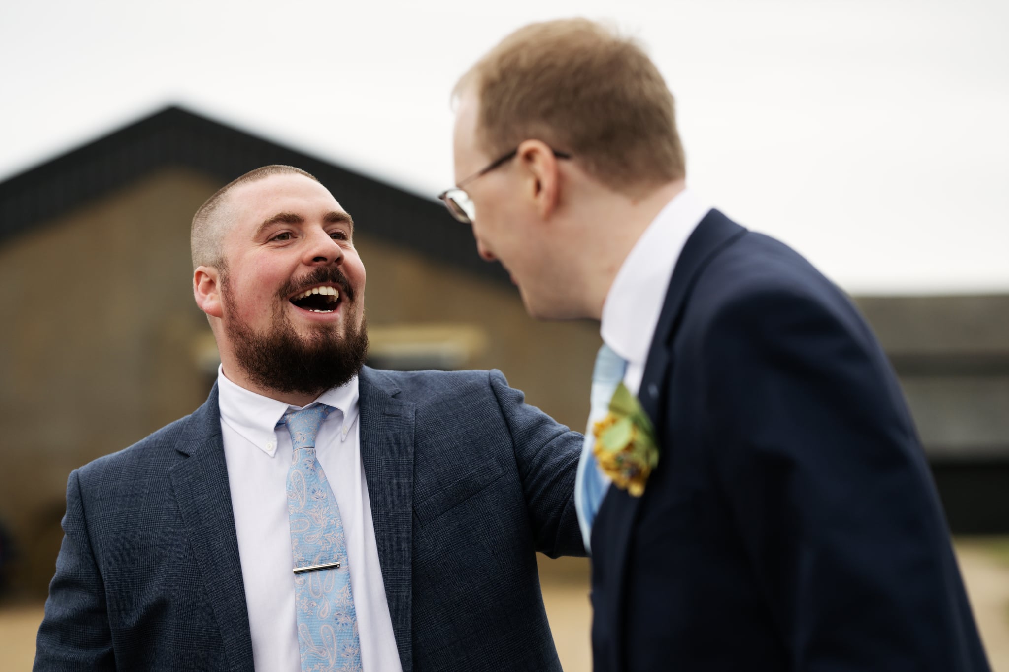 A candid photo of a guest chatting to the Groom.