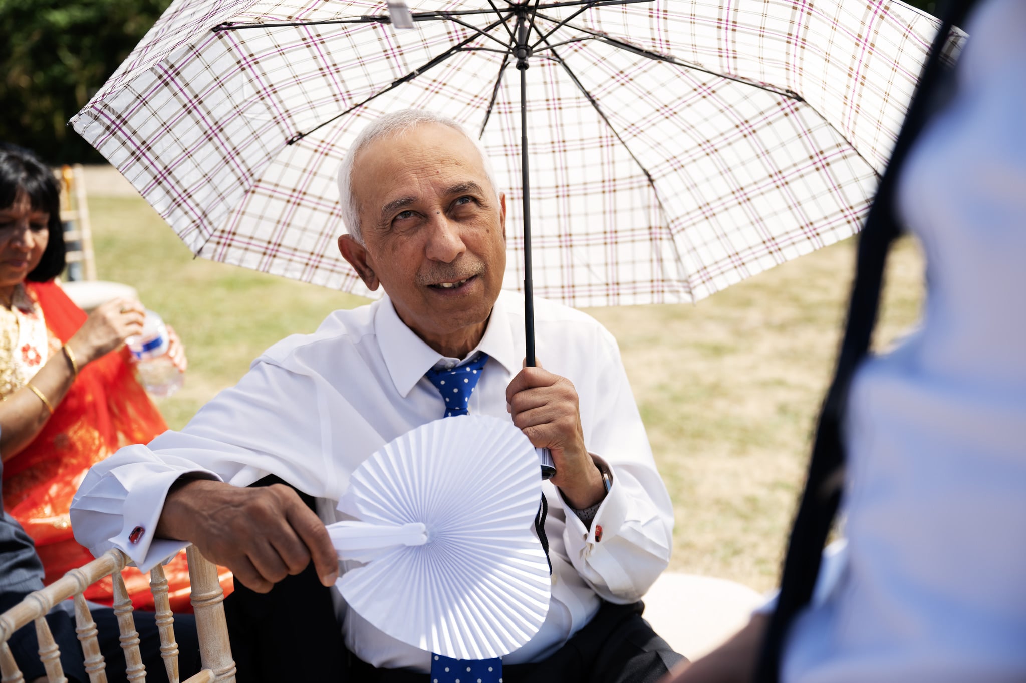 Candid wedding photo of a guest holding an umbrella