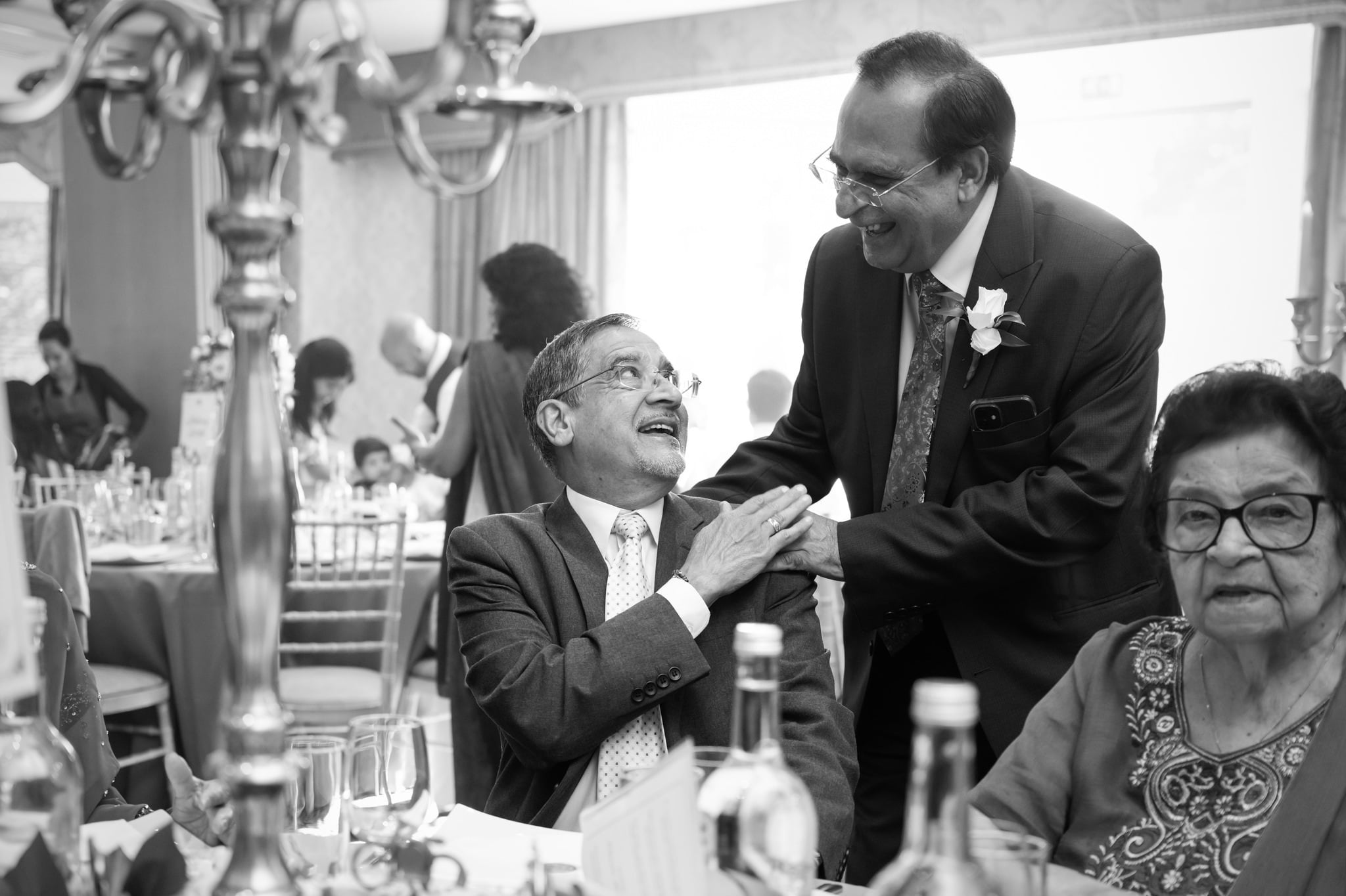 Documentary wedding photography capturing guests chatting with each other.
