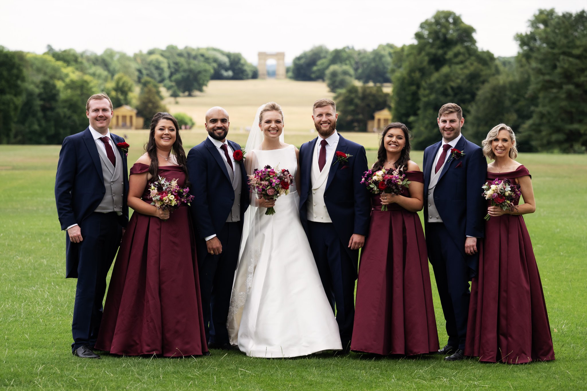 A group portrait of the bride and groom with their bridal party at Stowe House.