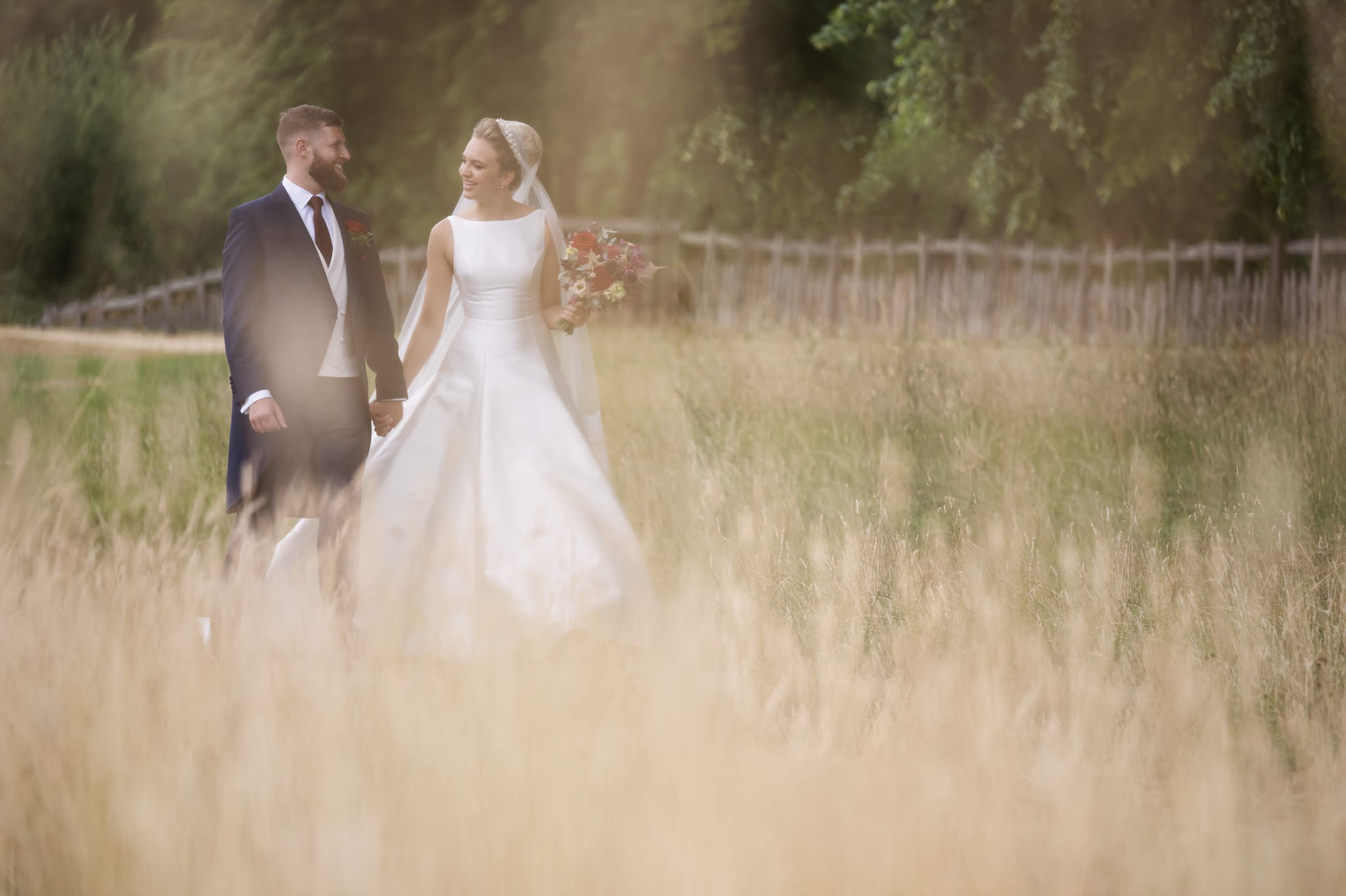 A portrait of the bride and groom walking in the grounds of Stowe House.