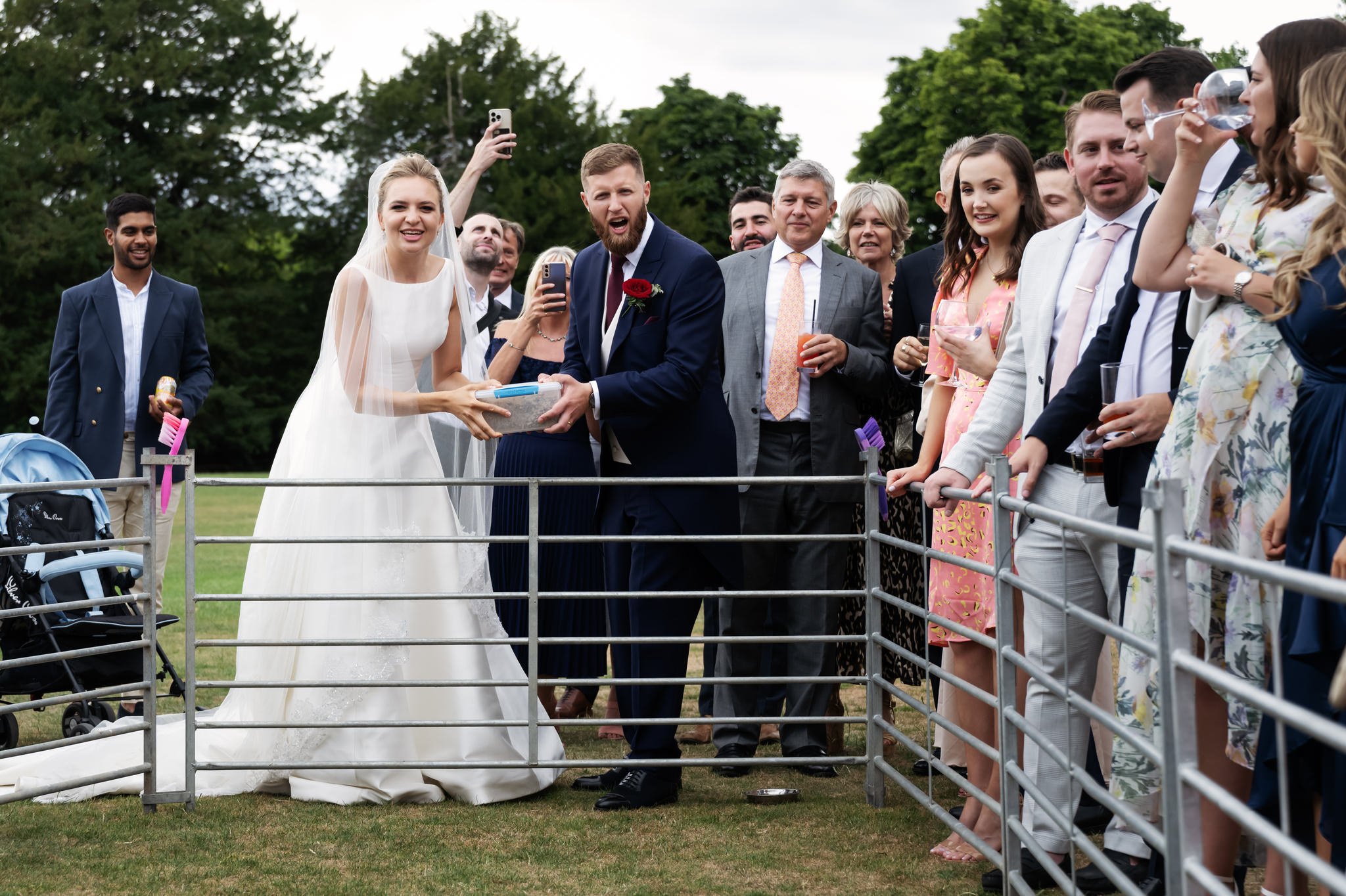 The bride and groom cheer on racing pigs at their wedding at Stowe School.