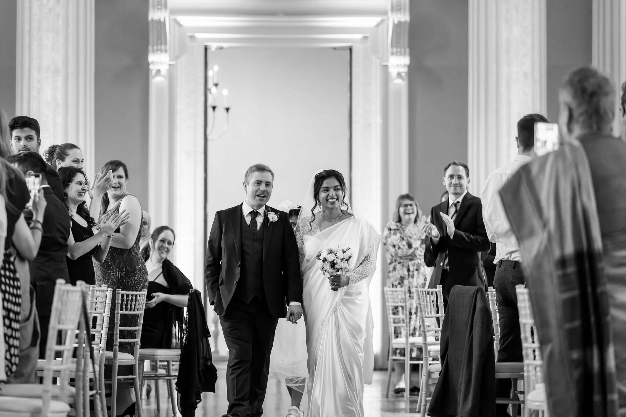 The bride and groom make their big entrance at a wedding at Banqueting House in London.