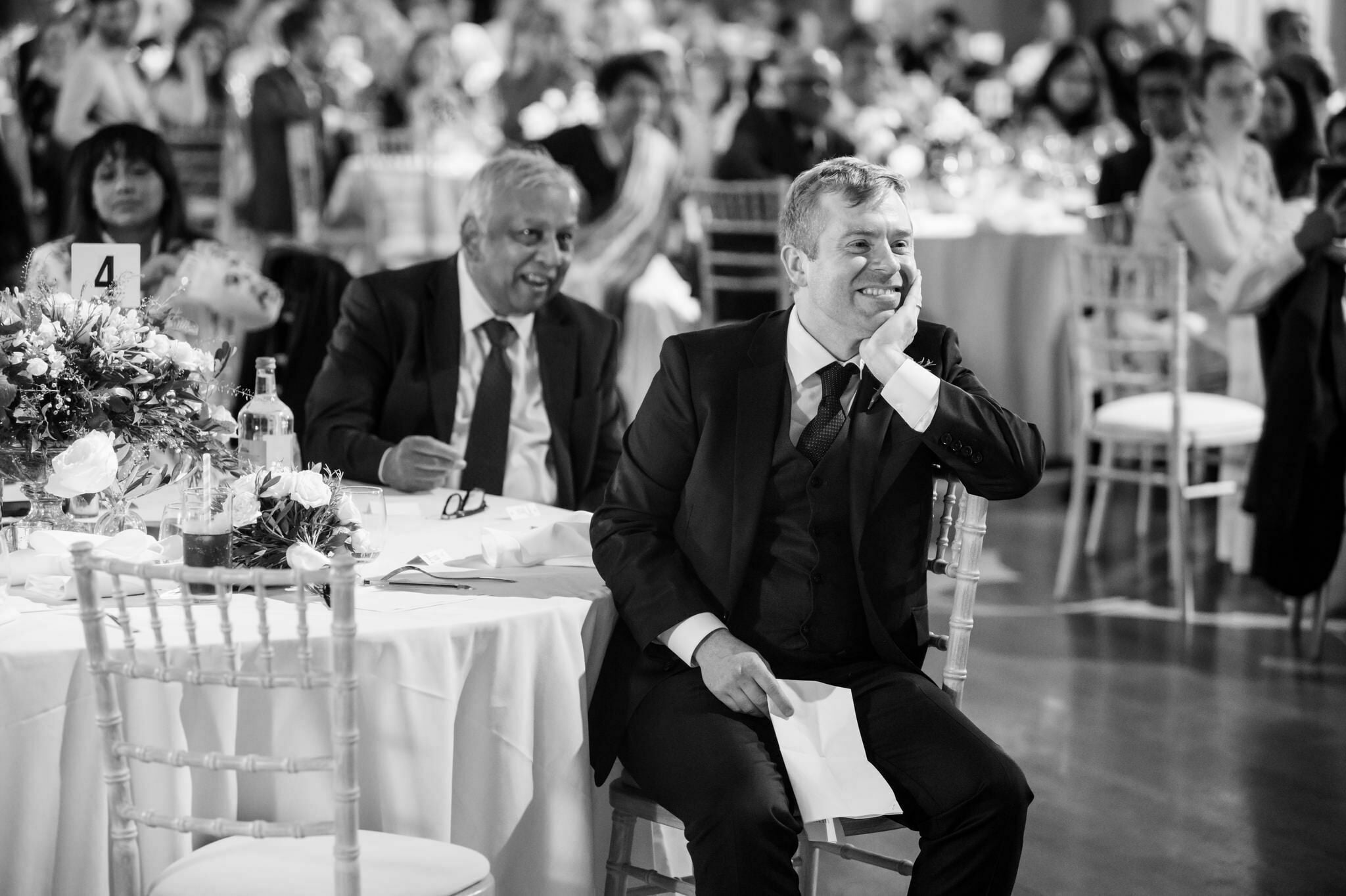 The groom listening to the Brides wedding speech.