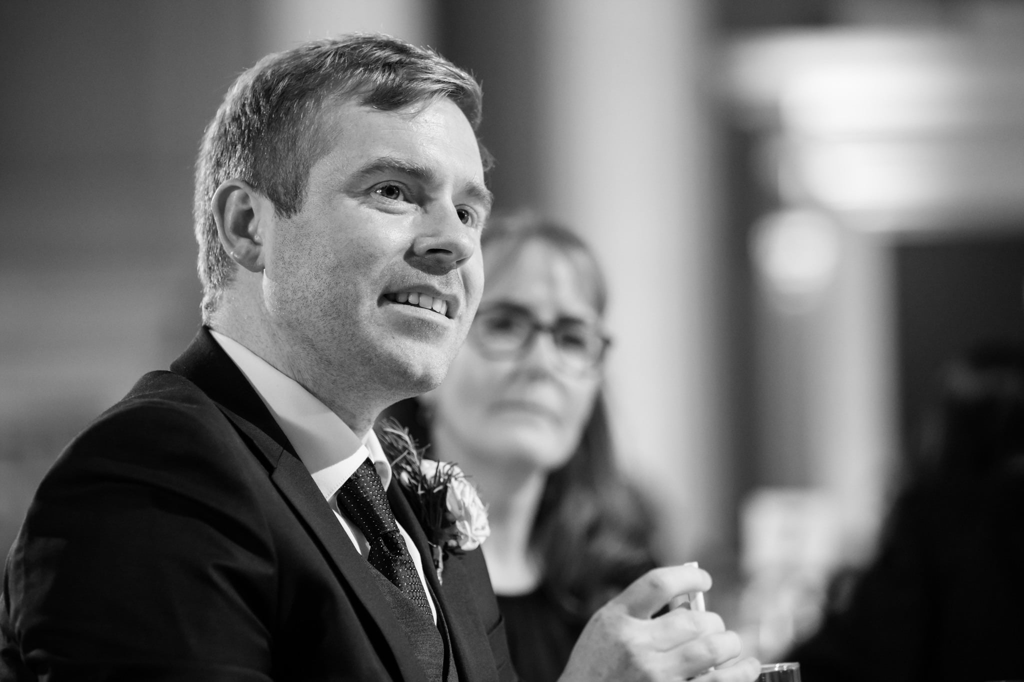 A close up photo of the groom listening to the speeches
