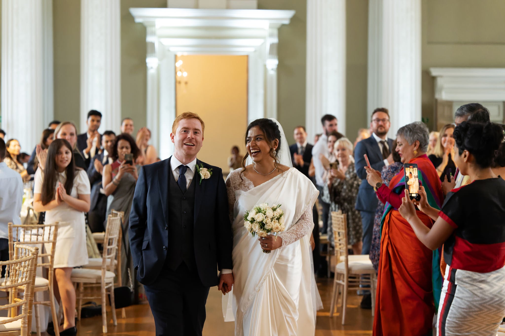The bride and groom make their big entrance at a wedding at Banqueting House in London.