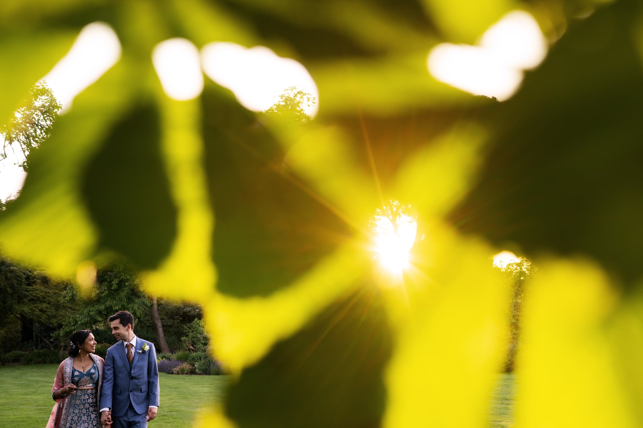 Bride and groom walking in the grounds of Redcoats Barn