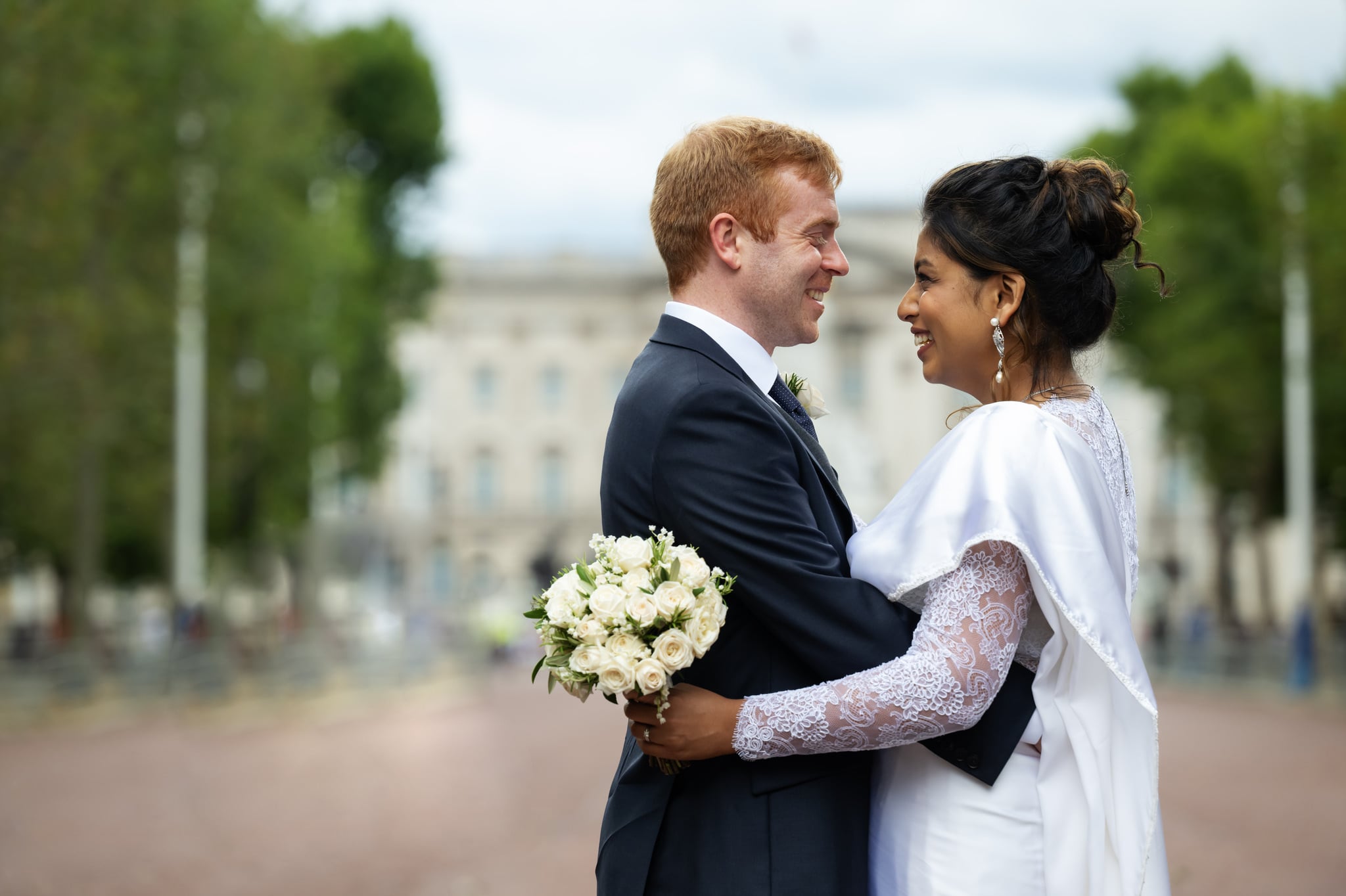 Portrait of the bride and groom on The Mall in London with Buckingham Palace in the background