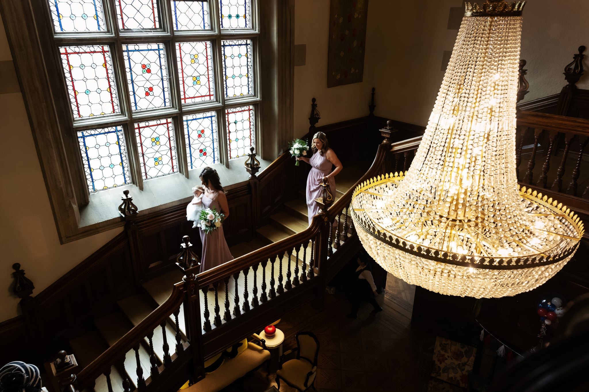 Bridesmaids walking down the grand staircase at Pendley Manor Hotel.