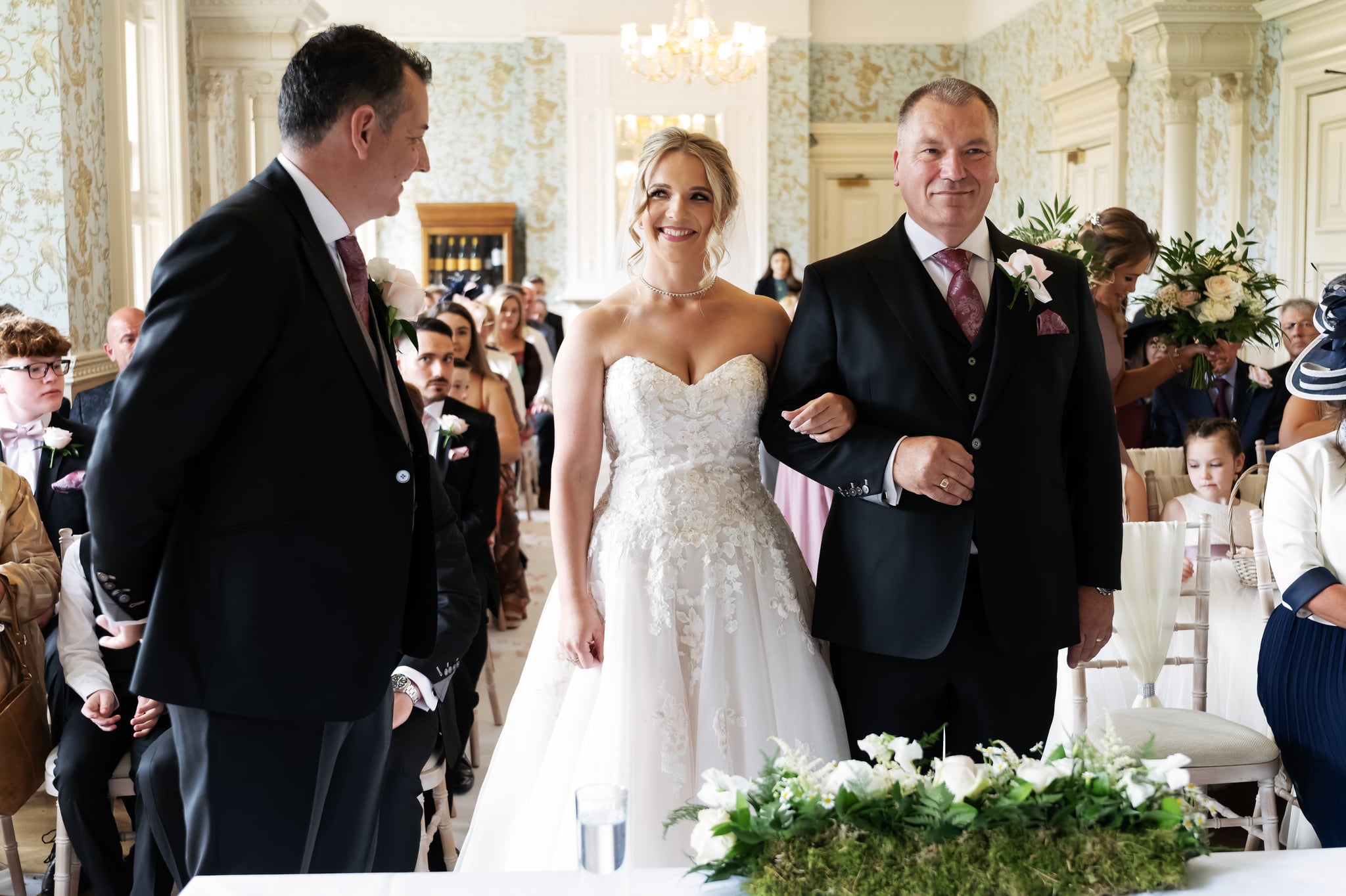 The bride reacts to seeing the groom at the start of the wedding ceremony.
