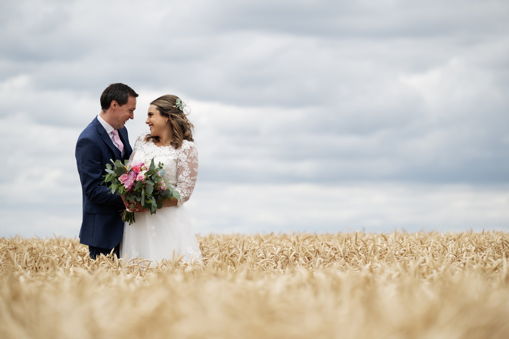 Portrait of the bride and groom in a barley field.