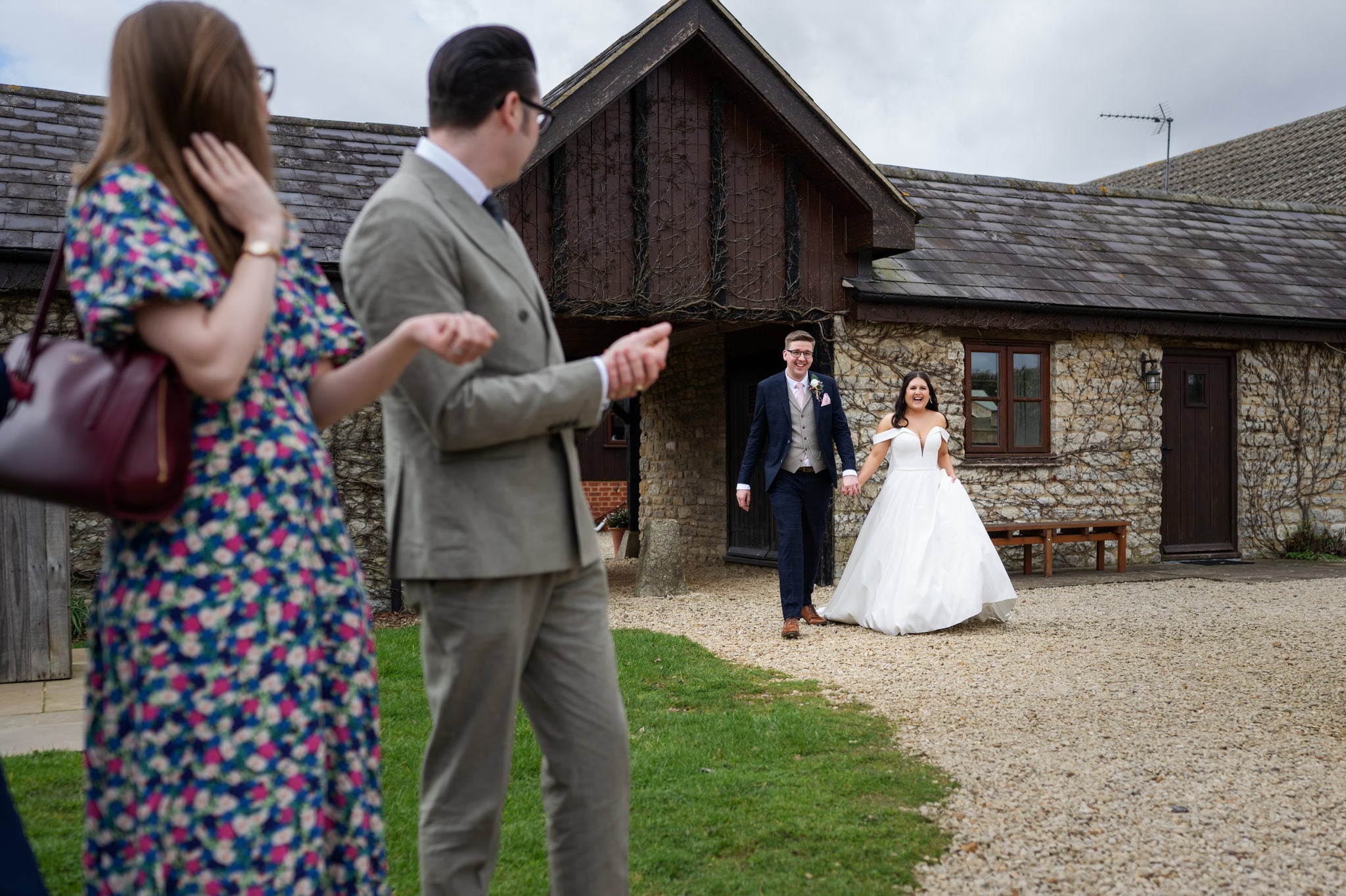 A bride and groom captured by the Huntsmill Farm Wedding Photographer walking away from a building.