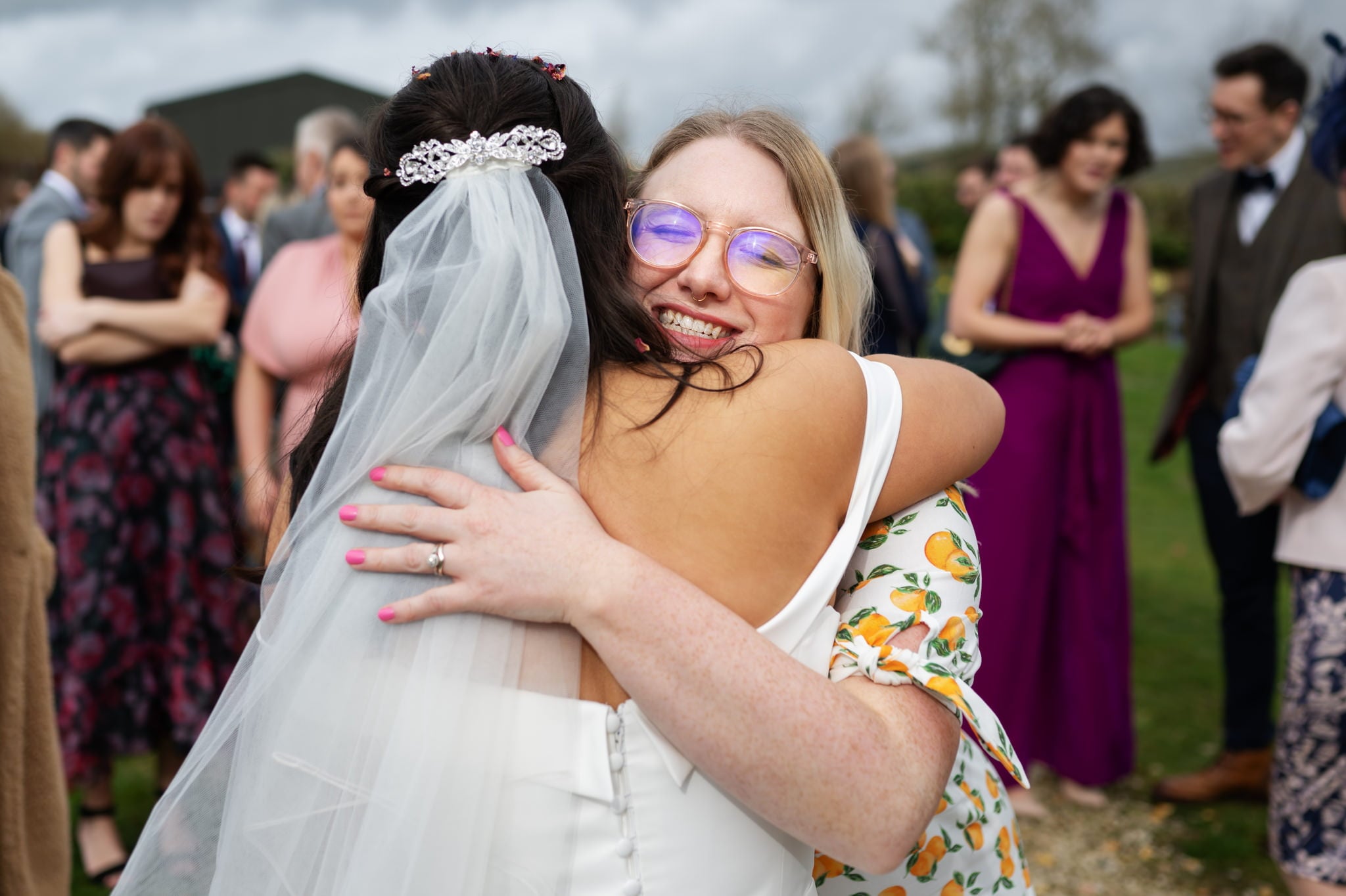 A bride hugging her bridesmaid captured at a Huntsmill Farm wedding by a talented photographer.