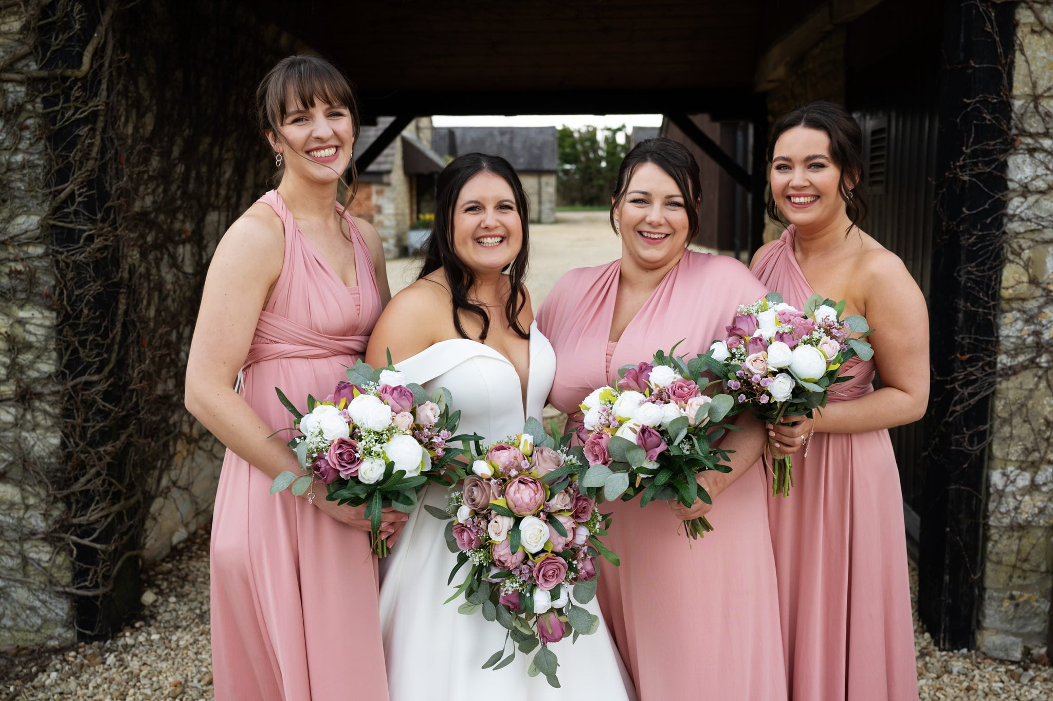Huntsmill Farm Wedding Photographer captures four bridesmaids in pink dresses posing for a photo.