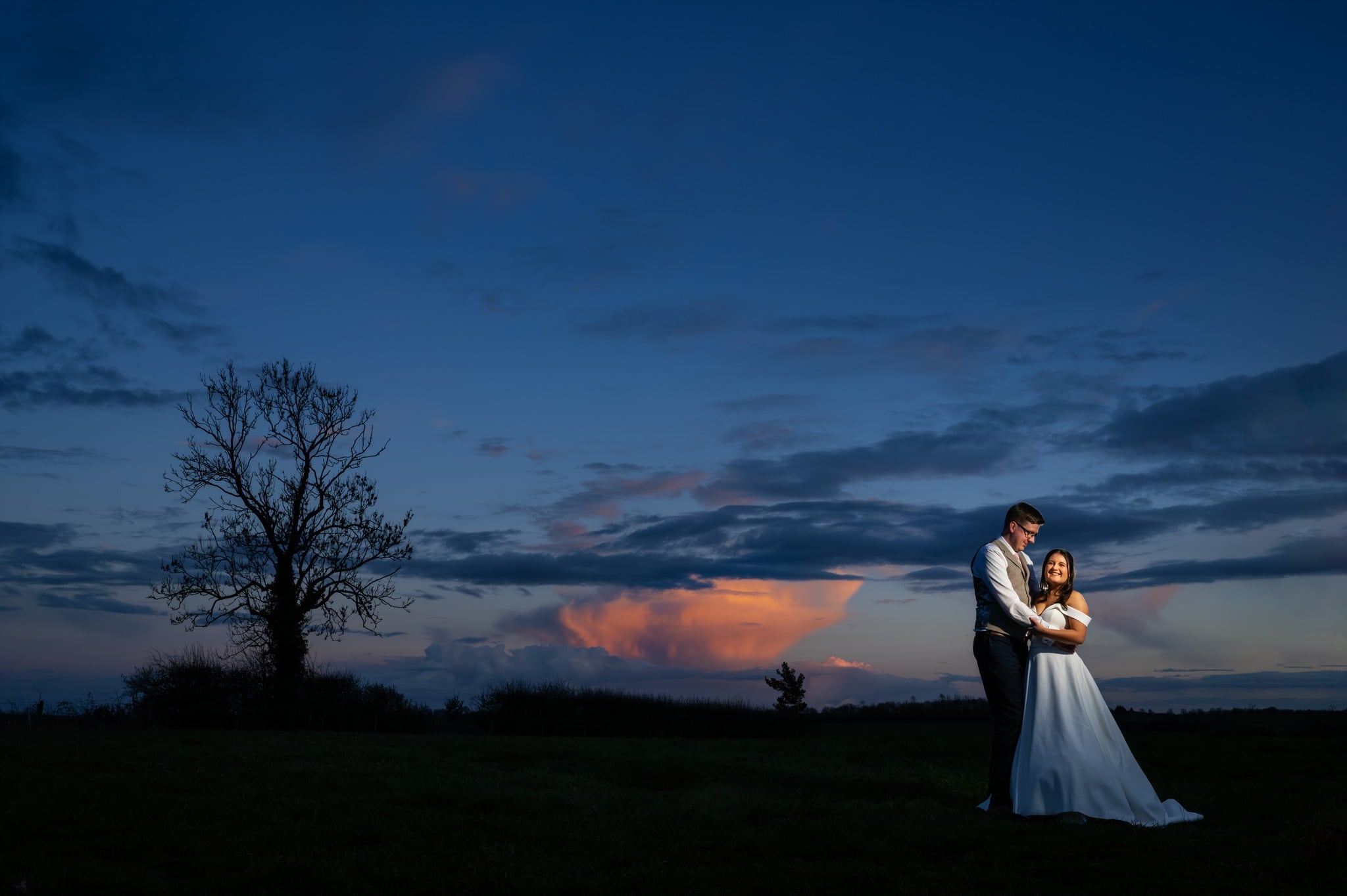 A bride and groom captured by the Huntsmill Farm wedding photographer in a beautiful field at sunset.