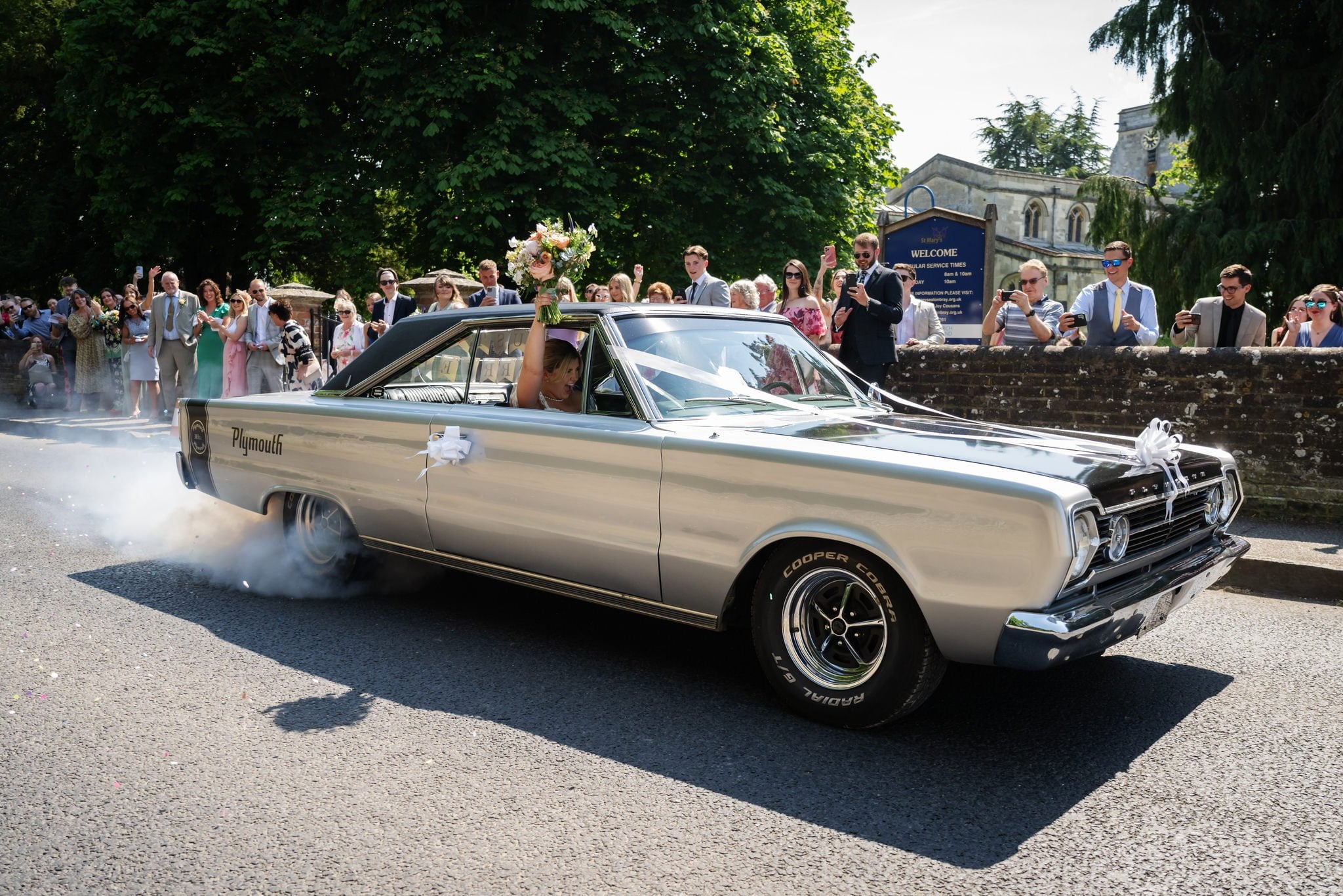 Bride and groom speeding off from the church in their wedding car on the way too Bunkers Barn