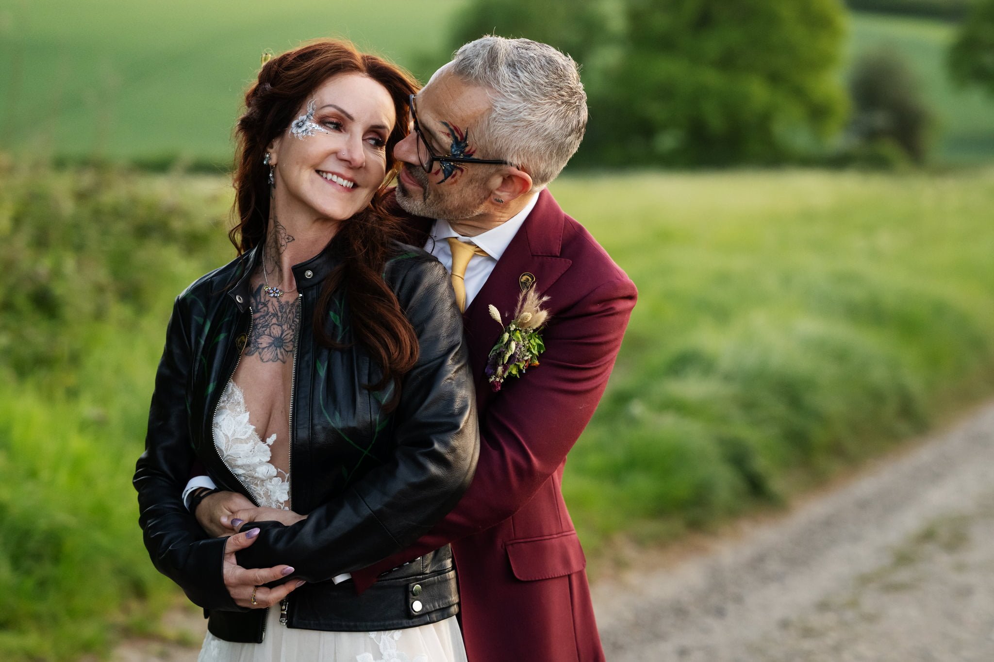 A bride and groom hugging on a country road.