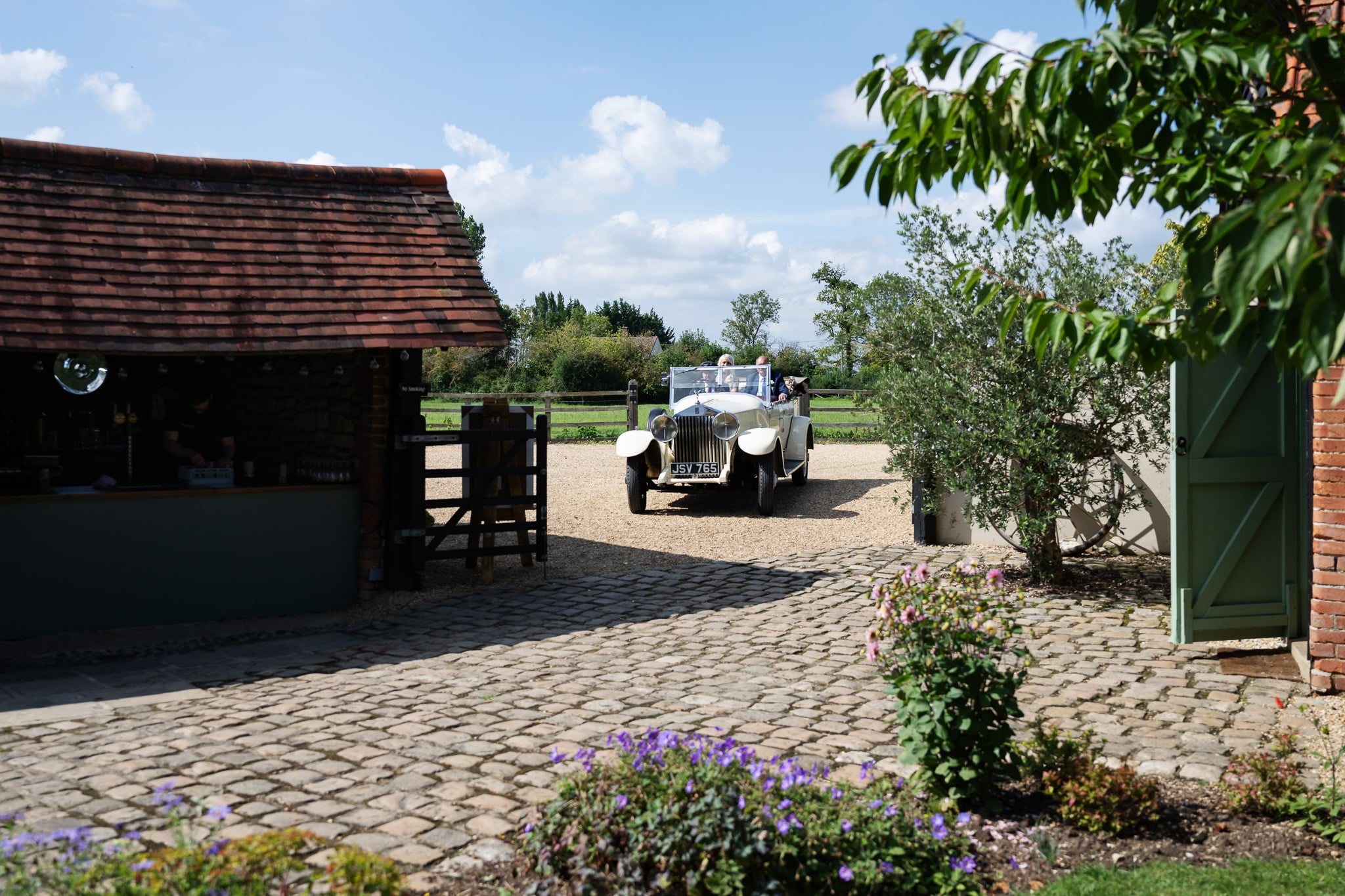 A brick driveway with a car parked in it.