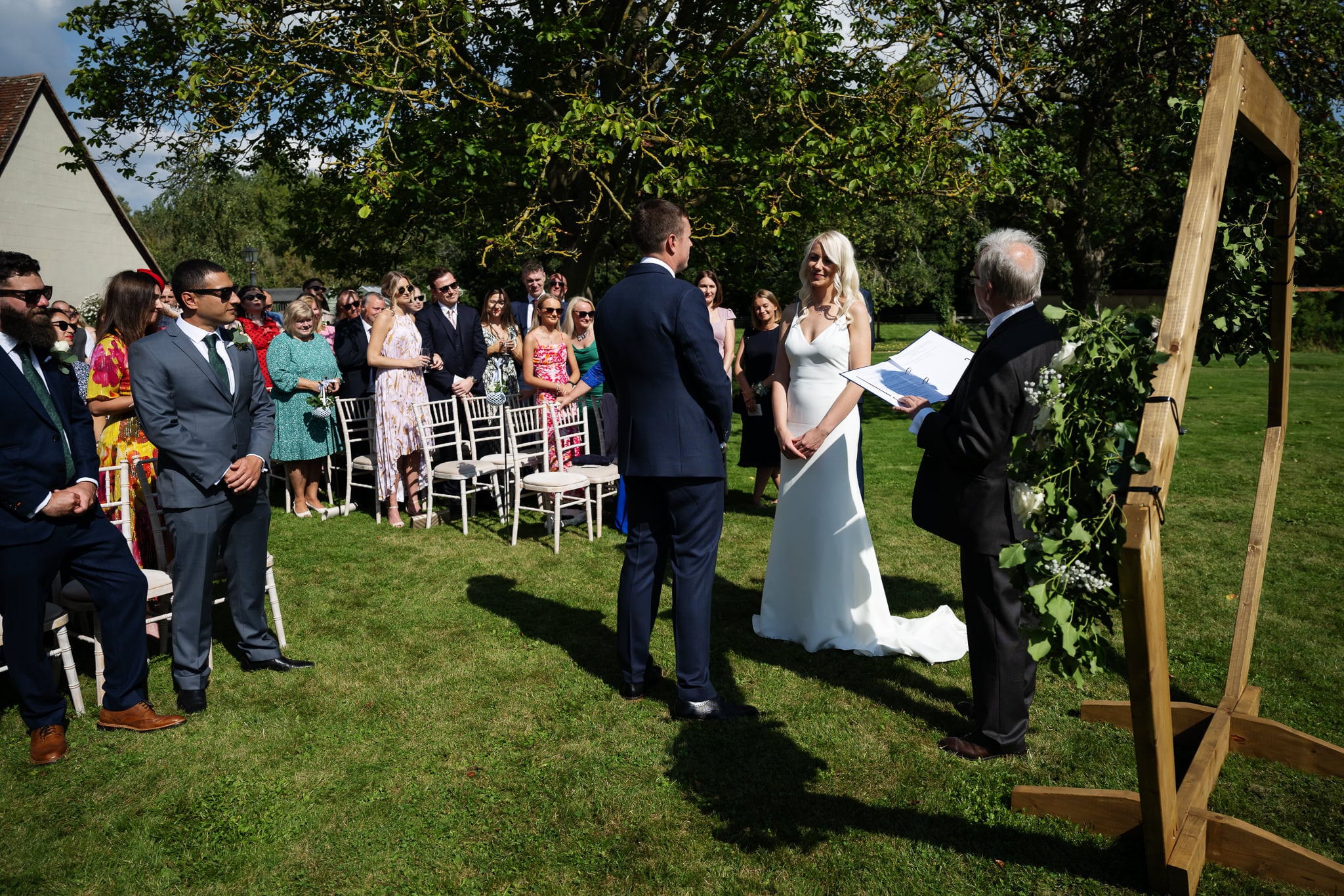 A wedding ceremony in a garden with a bride and groom.