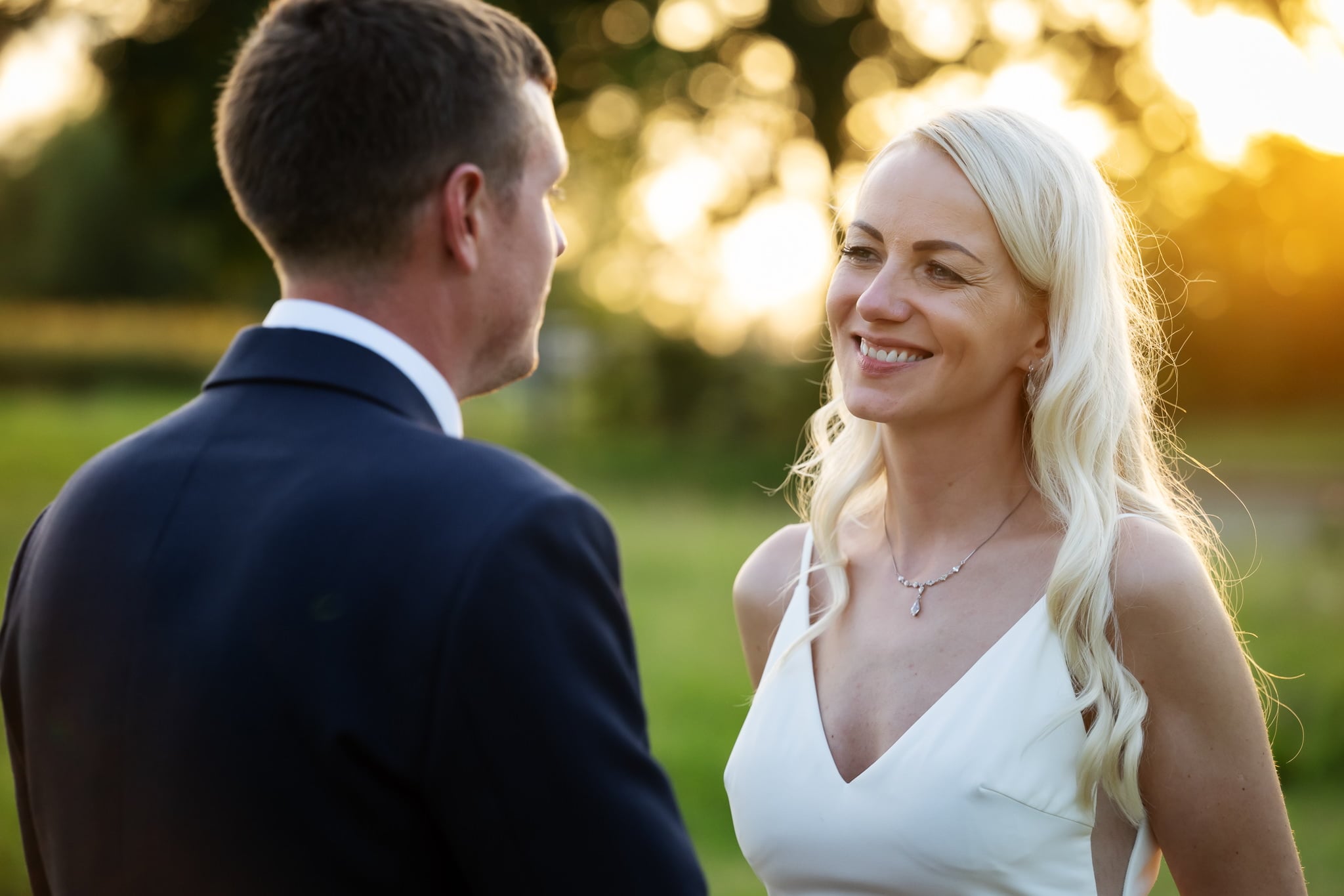 A bride and groom looking at each other at sunset.