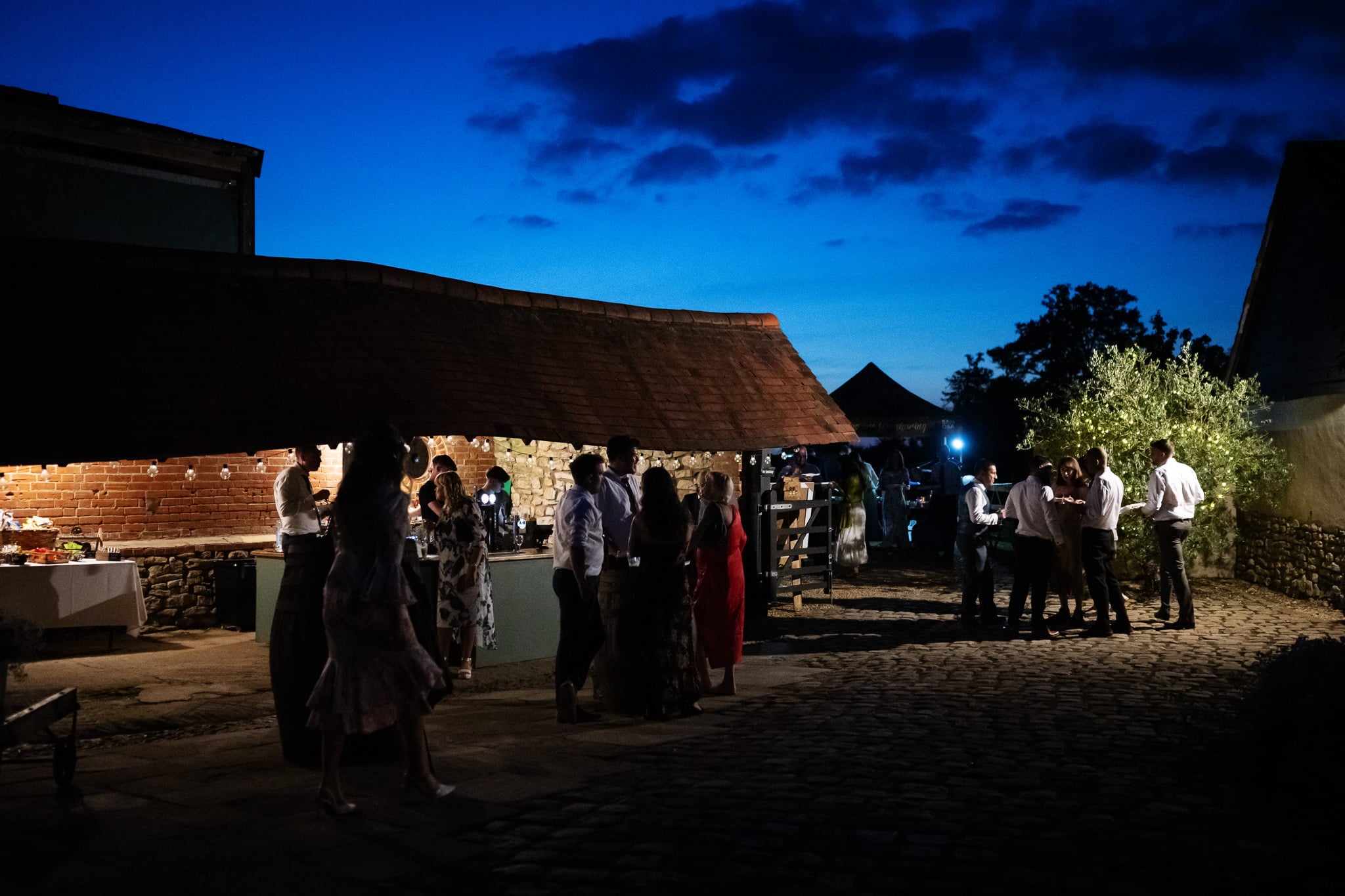 A group of people standing in a courtyard at night.
