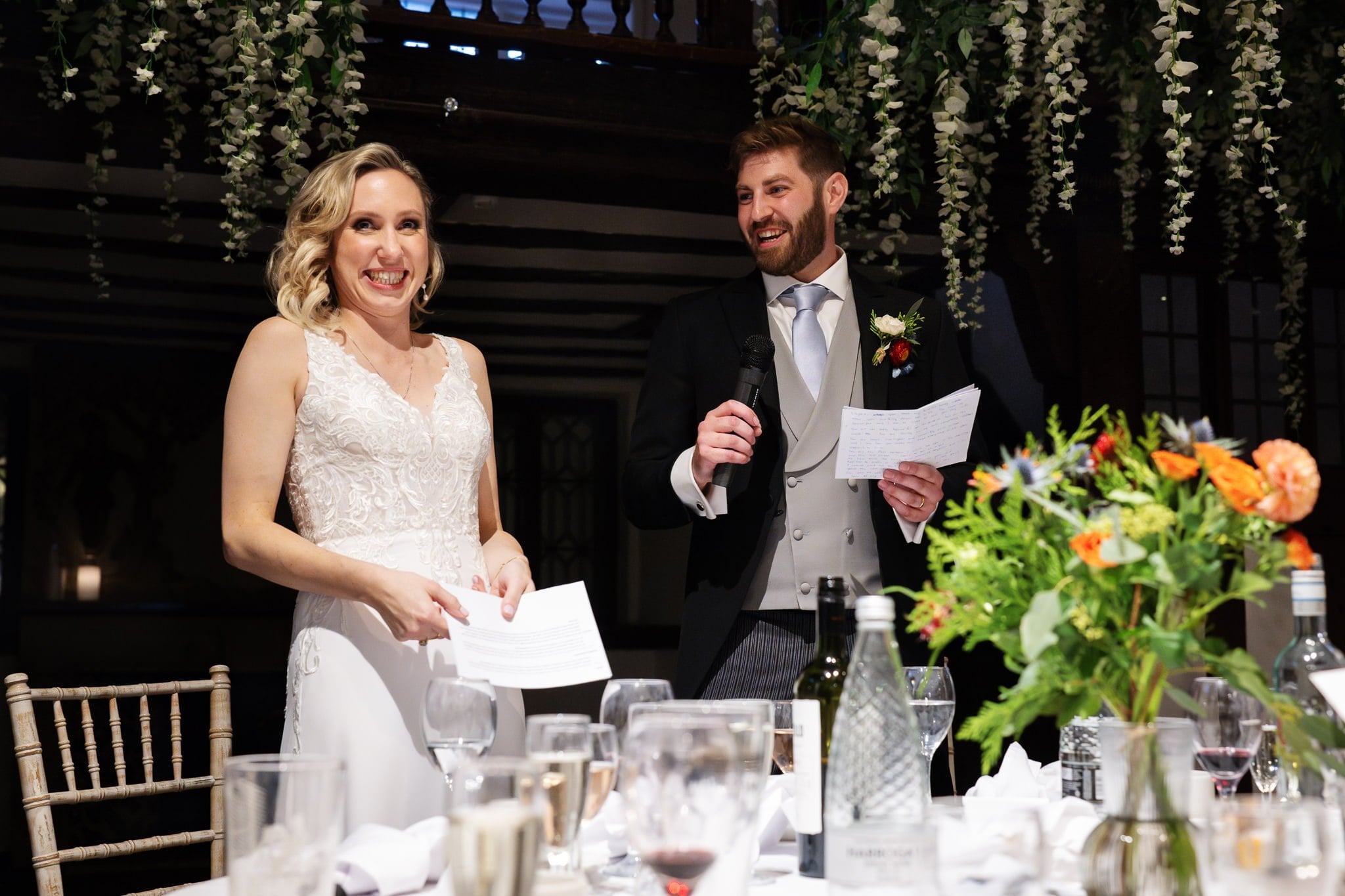 A bride and groom giving a speech at a wedding reception.
