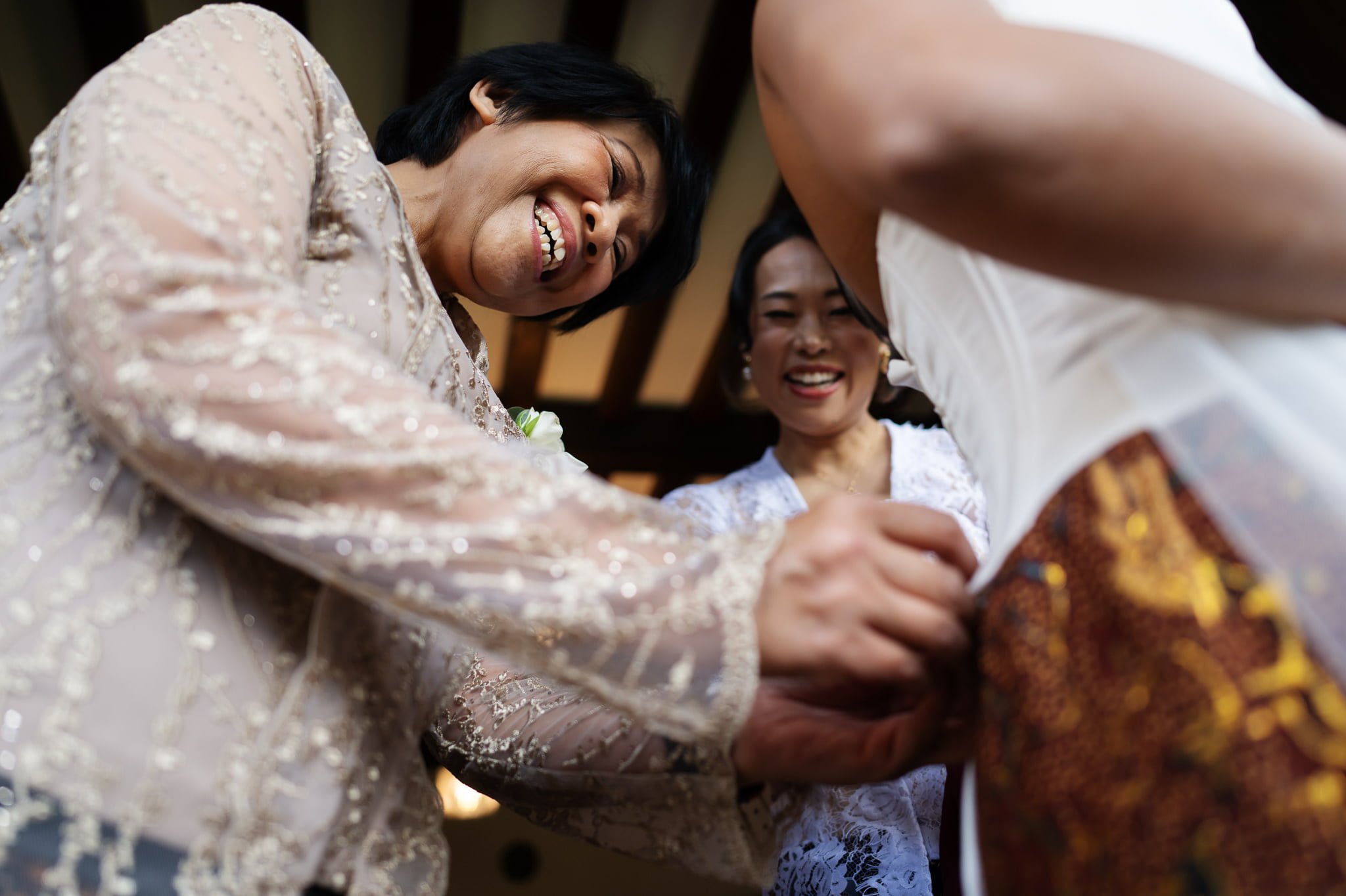 A bride is putting on her wedding dress.