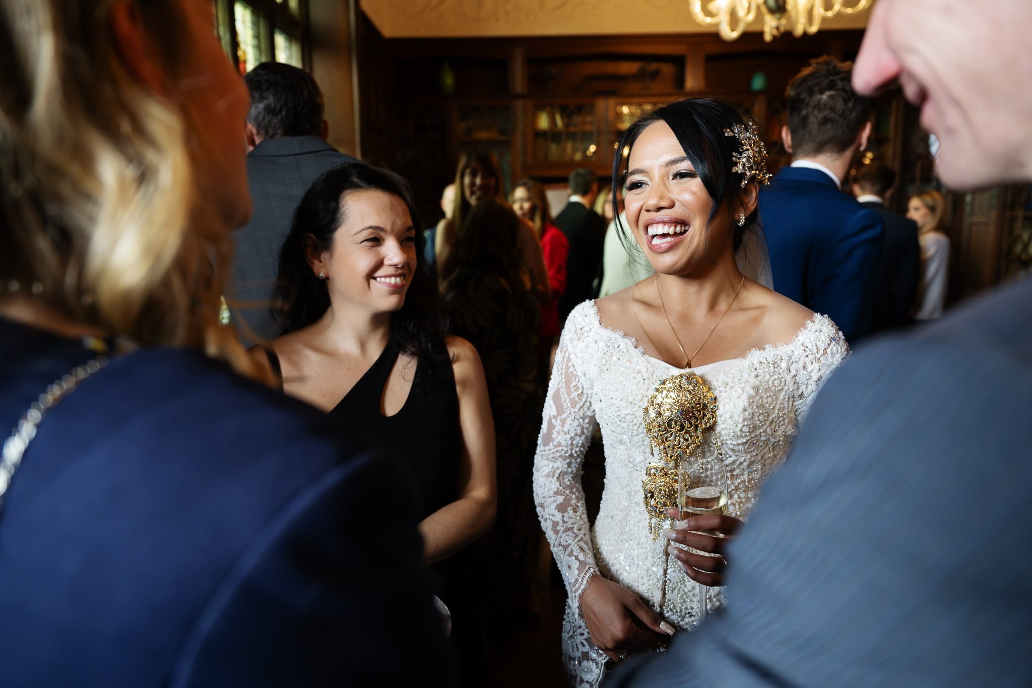 A bride in a wedding dress talking to people in a room.