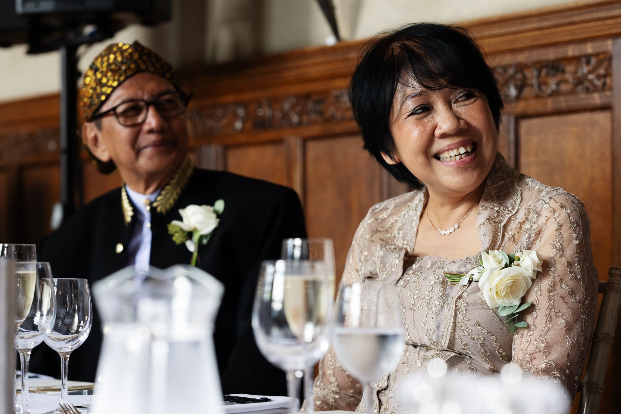 A man and woman smiling at each other at a wedding.
