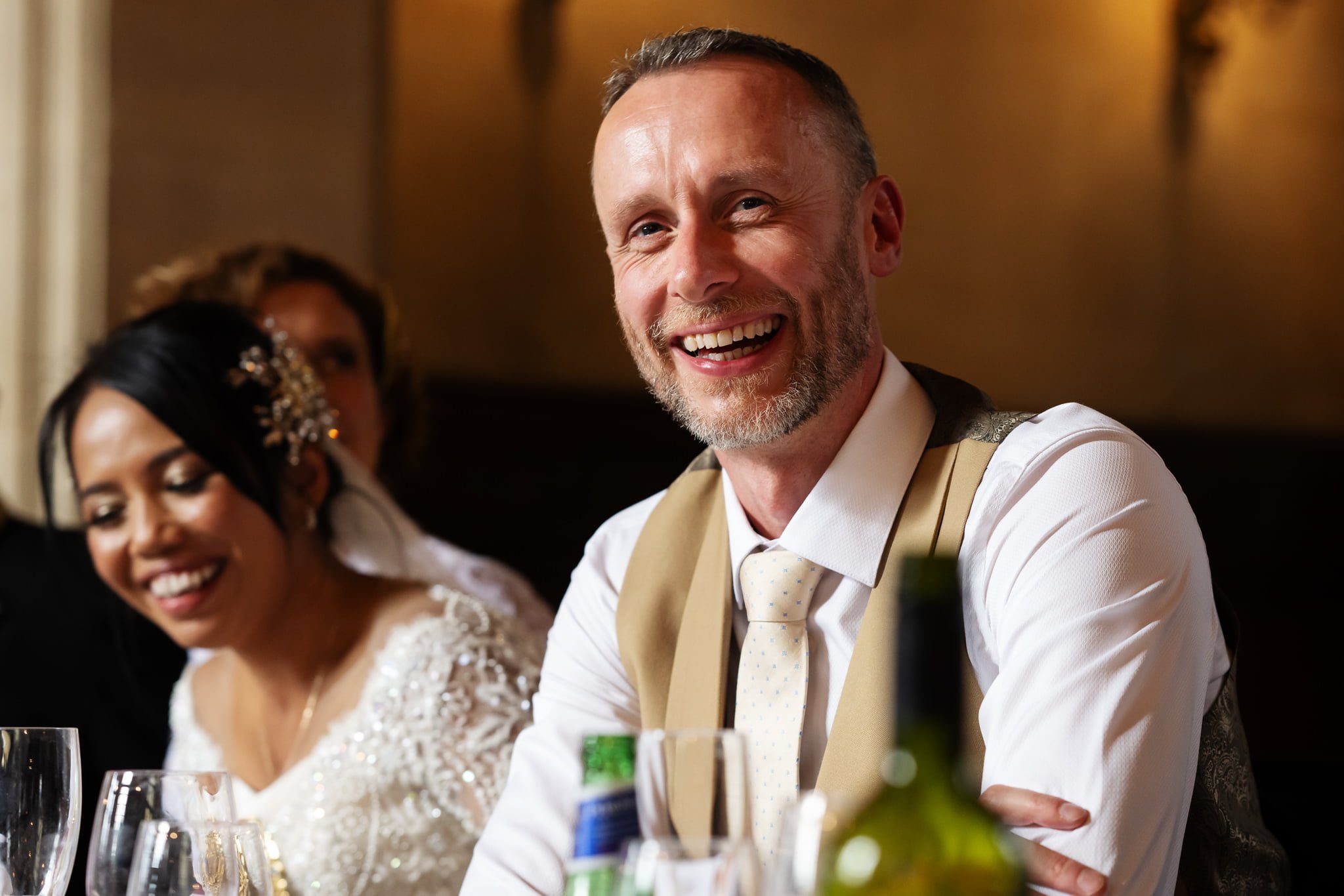 A bride and groom smiling at each other at a wedding reception.