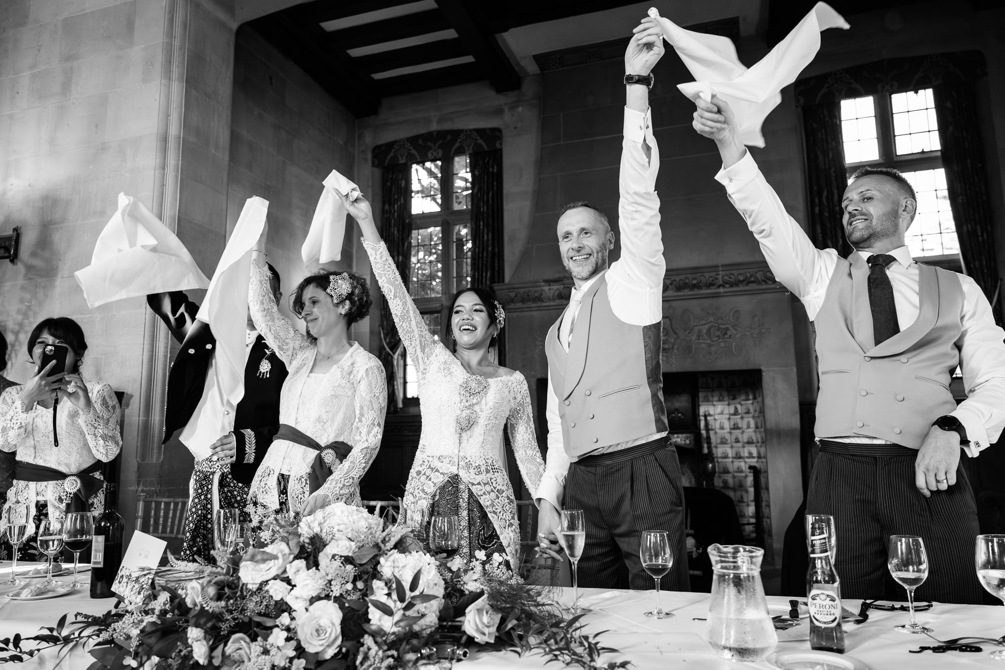 A group of people raising their hands in the air at a wedding.