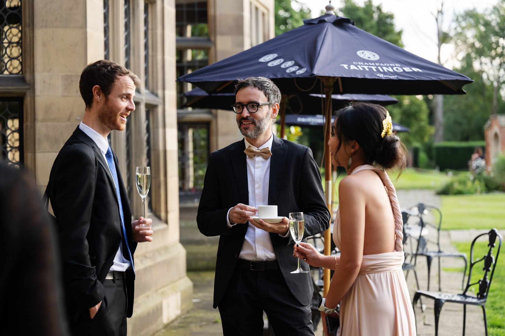 A group of people talking outside at a wedding reception.