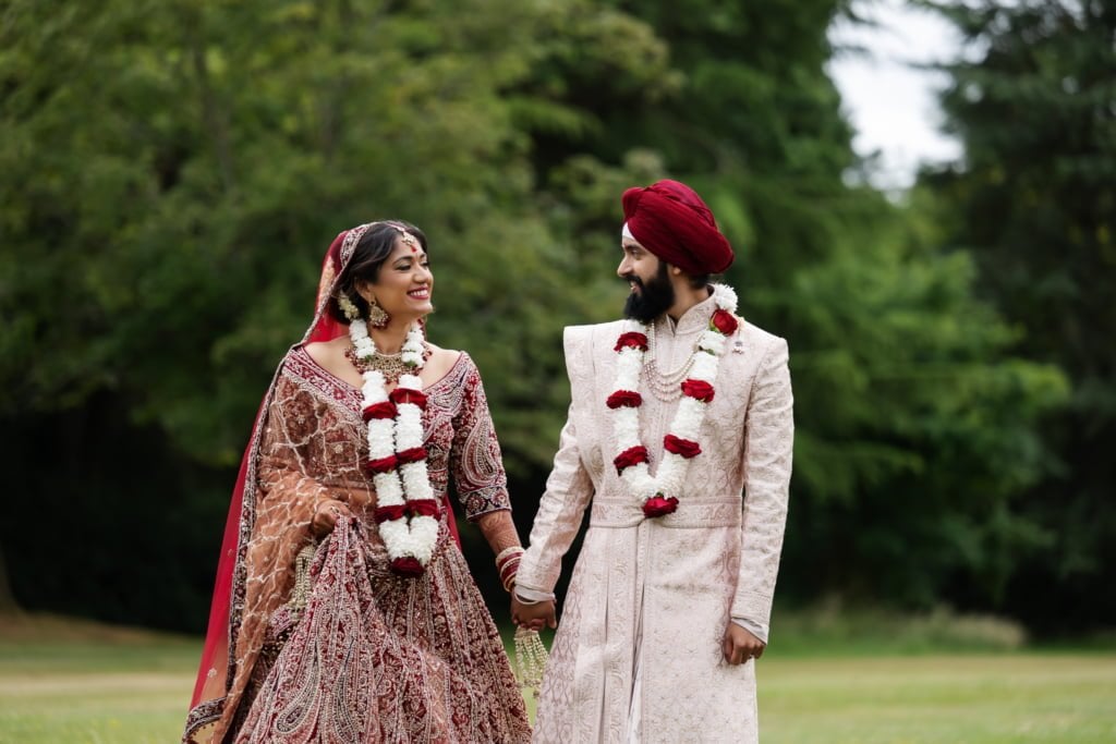 A portrait of an Indian bride and groom in the grounds at Shendish Manor