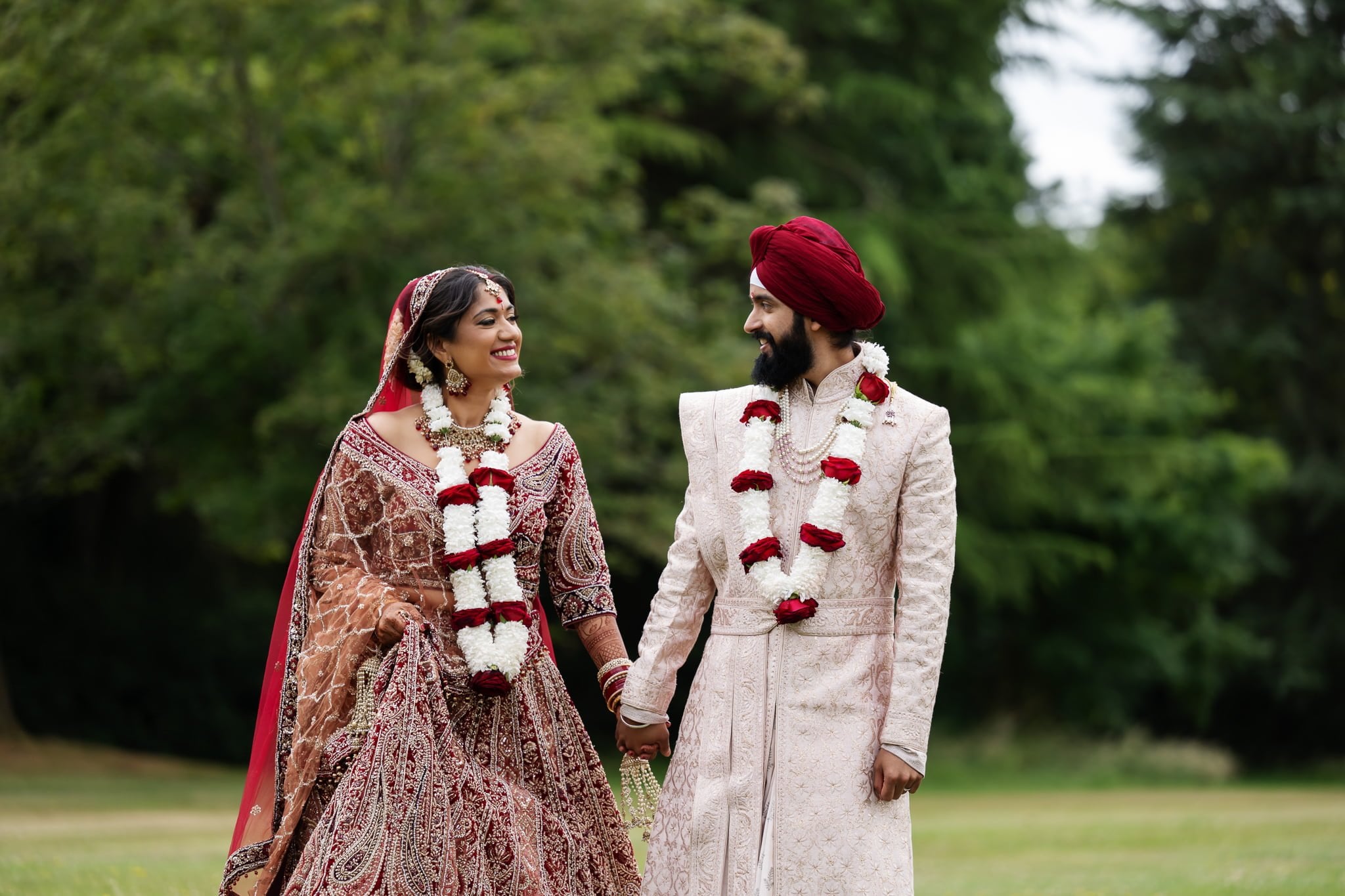 A portrait of an Indian bride and groom in the grounds at Shendish Manor