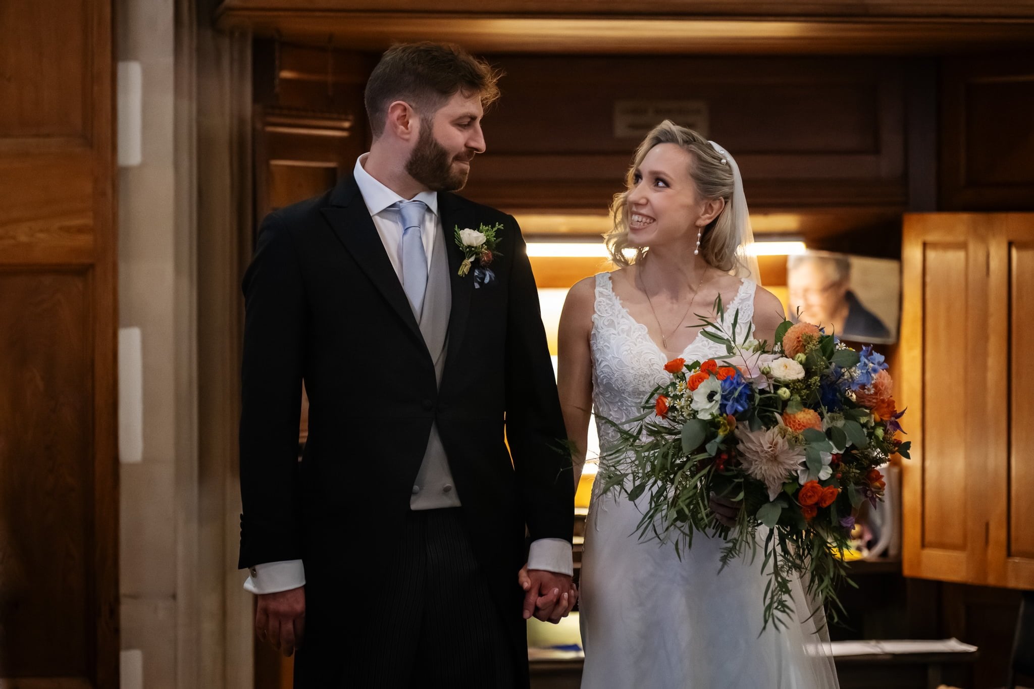 A bride and groom look at each other in a church.
