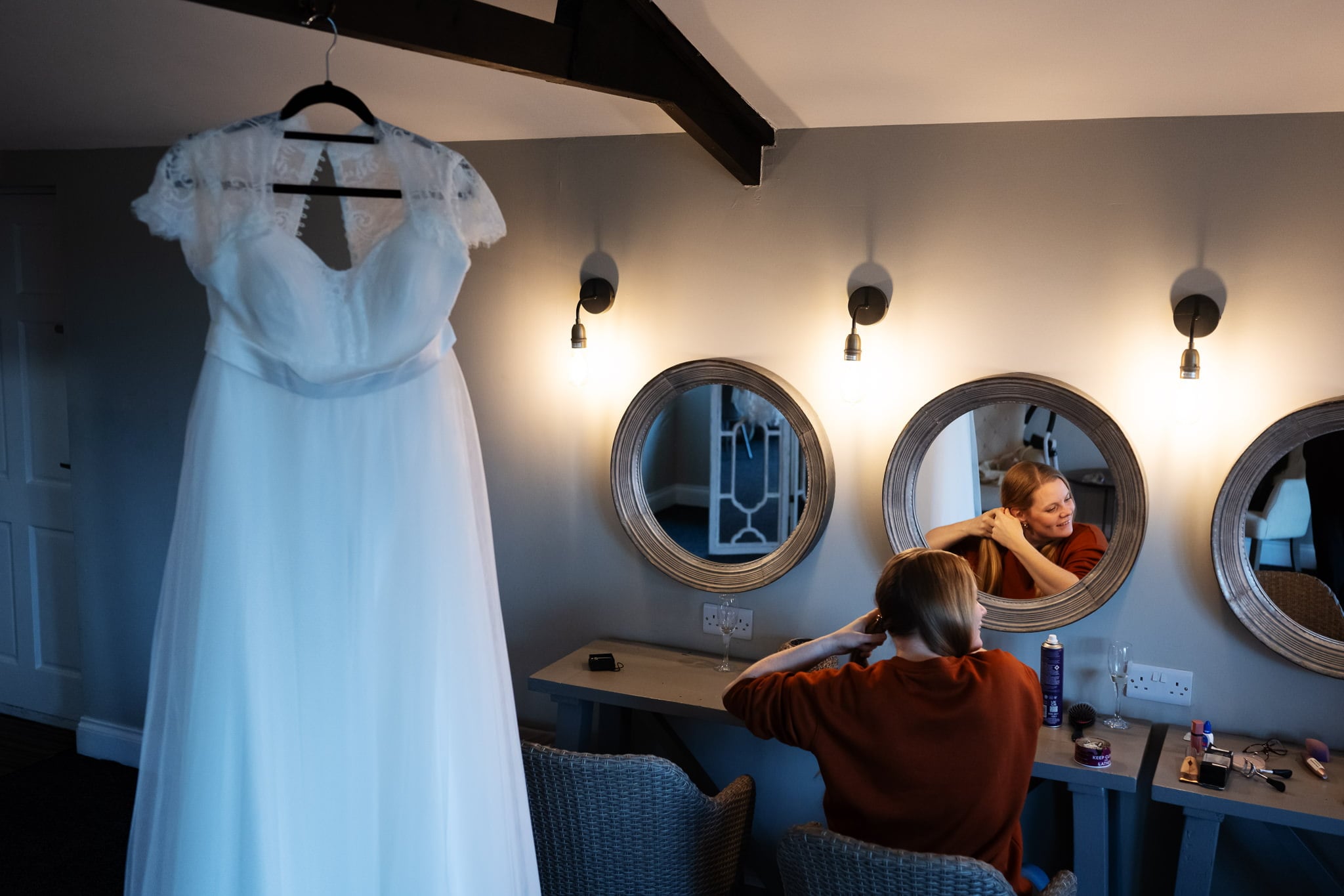 A bride getting ready in a room with mirrors.